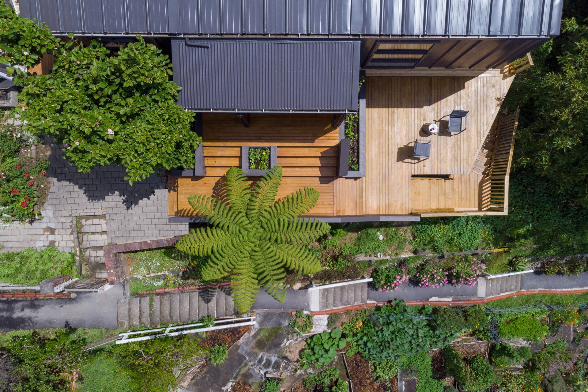 Decking has been used to extend the living space outdoors, seamlessly connecting with the sunspace module that features a set of bi-folding doors.