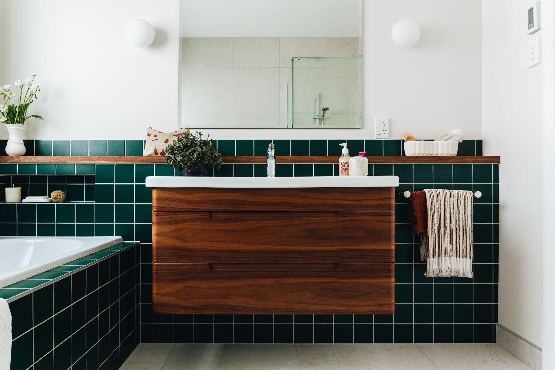 Green is the trendy tile colour of choice flowing from the bathtub and beyond in this Eastbourne residence.