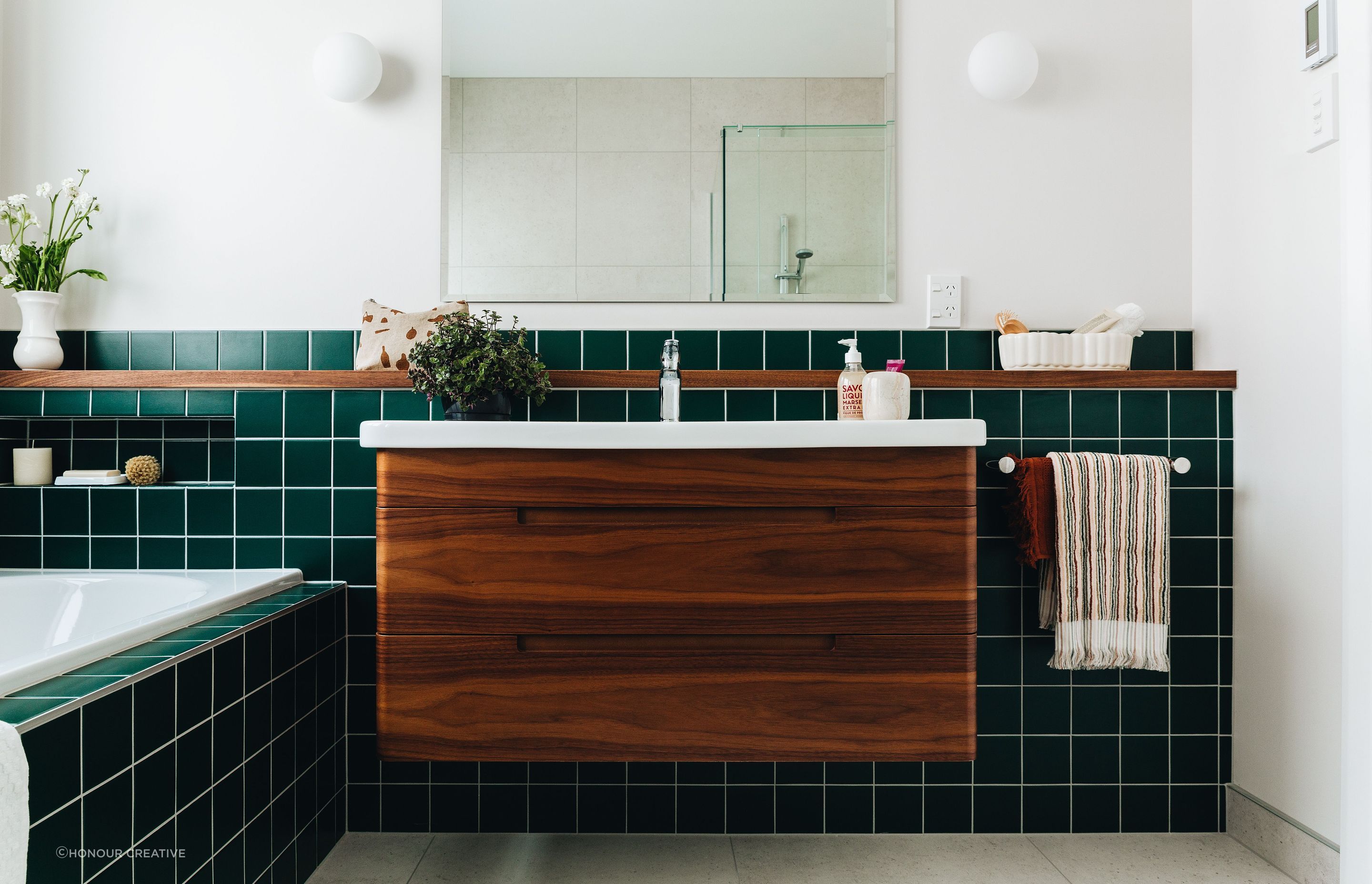 Green is the trendy tile colour of choice flowing from the bathtub and beyond in this Eastbourne residence.