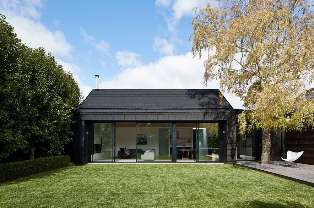 The dark exterior provides a striking contrast with the outdoor greenery. Photographer: Shannon McGrath.