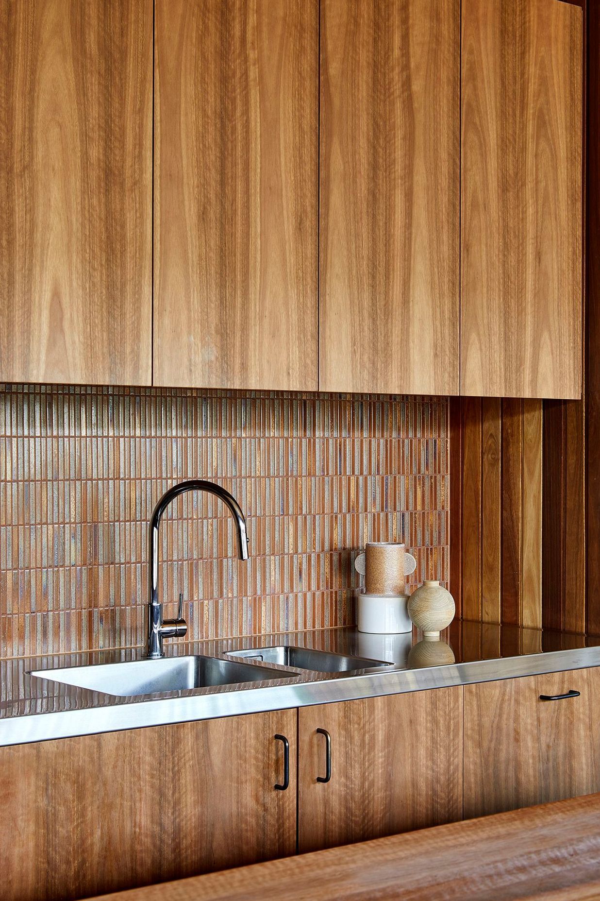 The subtle patina and lustre of the YB12 tiles create a focal point within the kitchen and call attention to the natural variation in the grain of the timber cabinetry.