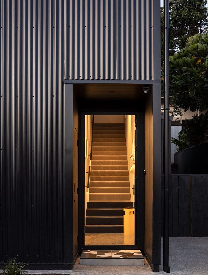 The front entrance features a geometric tiled entry mat.