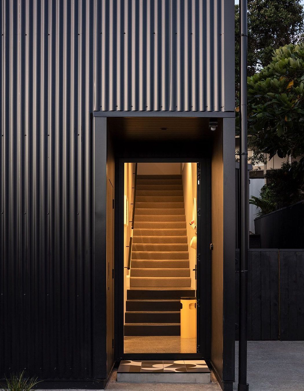 The front entrance features a geometric tiled entry mat.