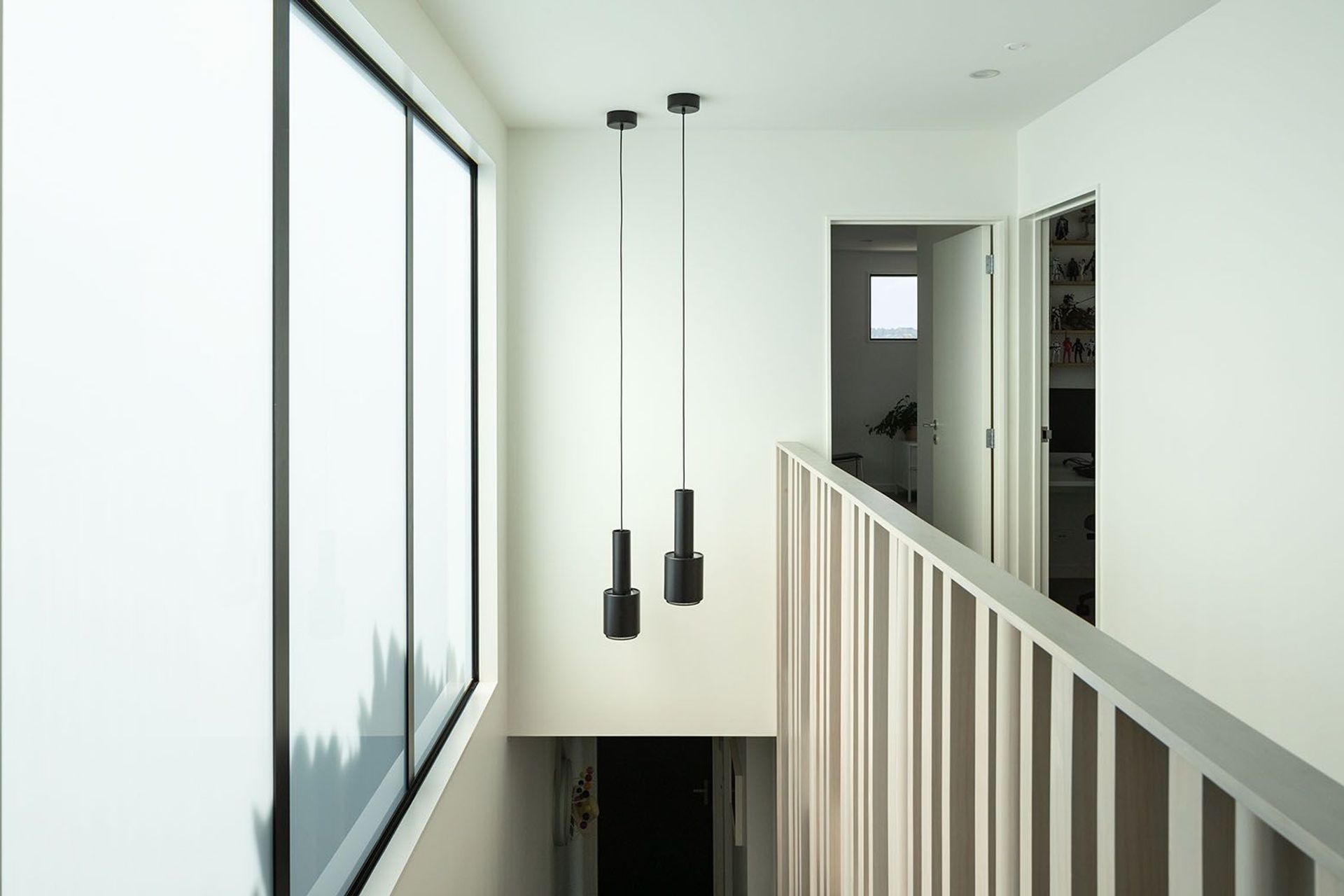 From upstairs, the staircase features frosted glass to bring in light while maintaining privacy.