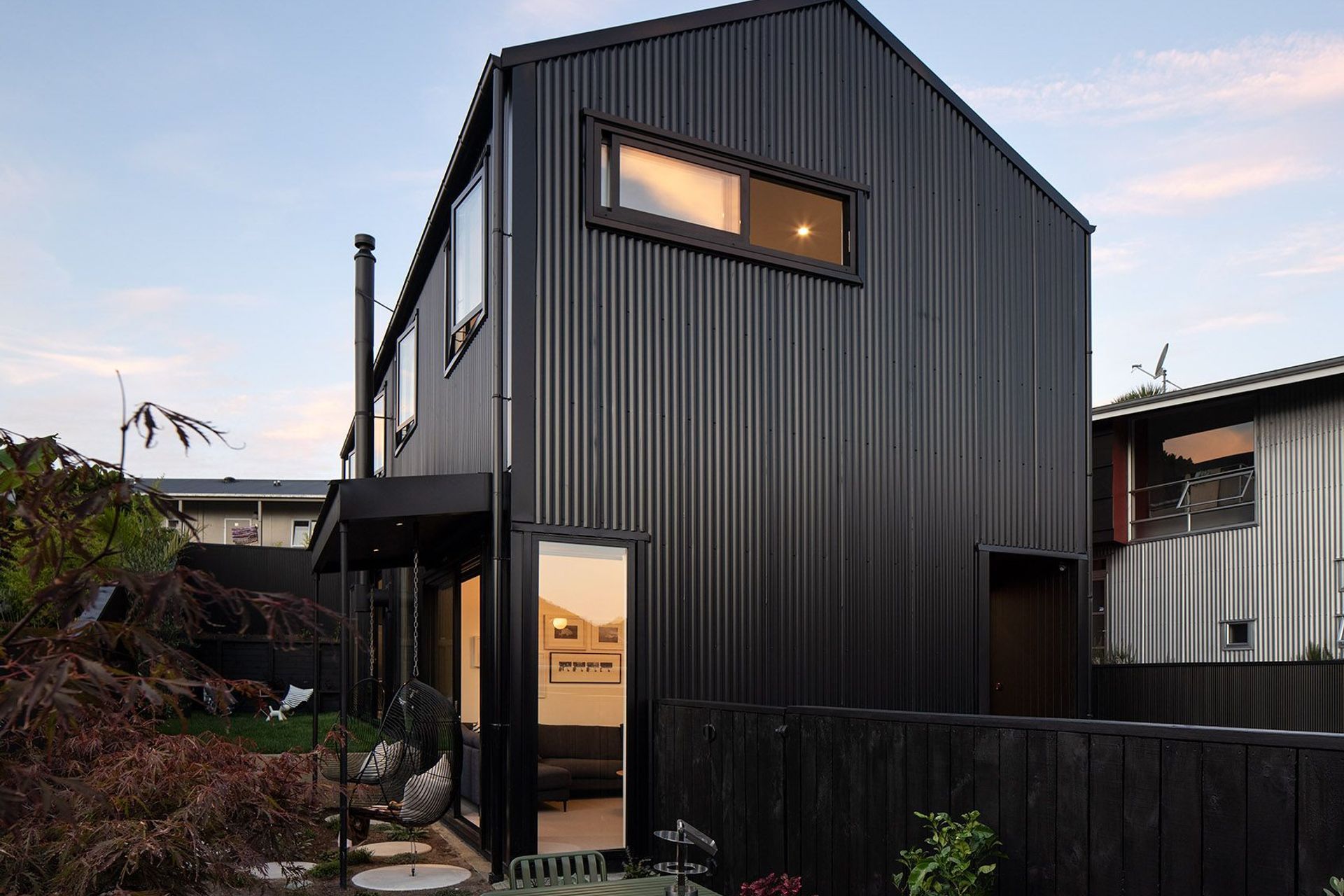 Clad in black corrugate, the front elevation casts a striking gabled form within its tight Grey Lynn site.