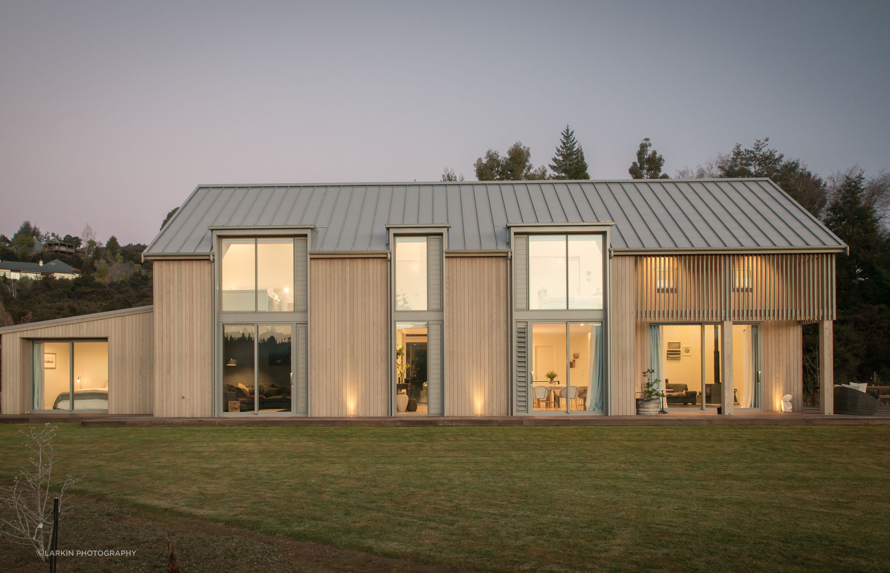Pale cedar pairs with the Sandstone Grey metal roofing, giving the home a Scandinavian aesthetic.