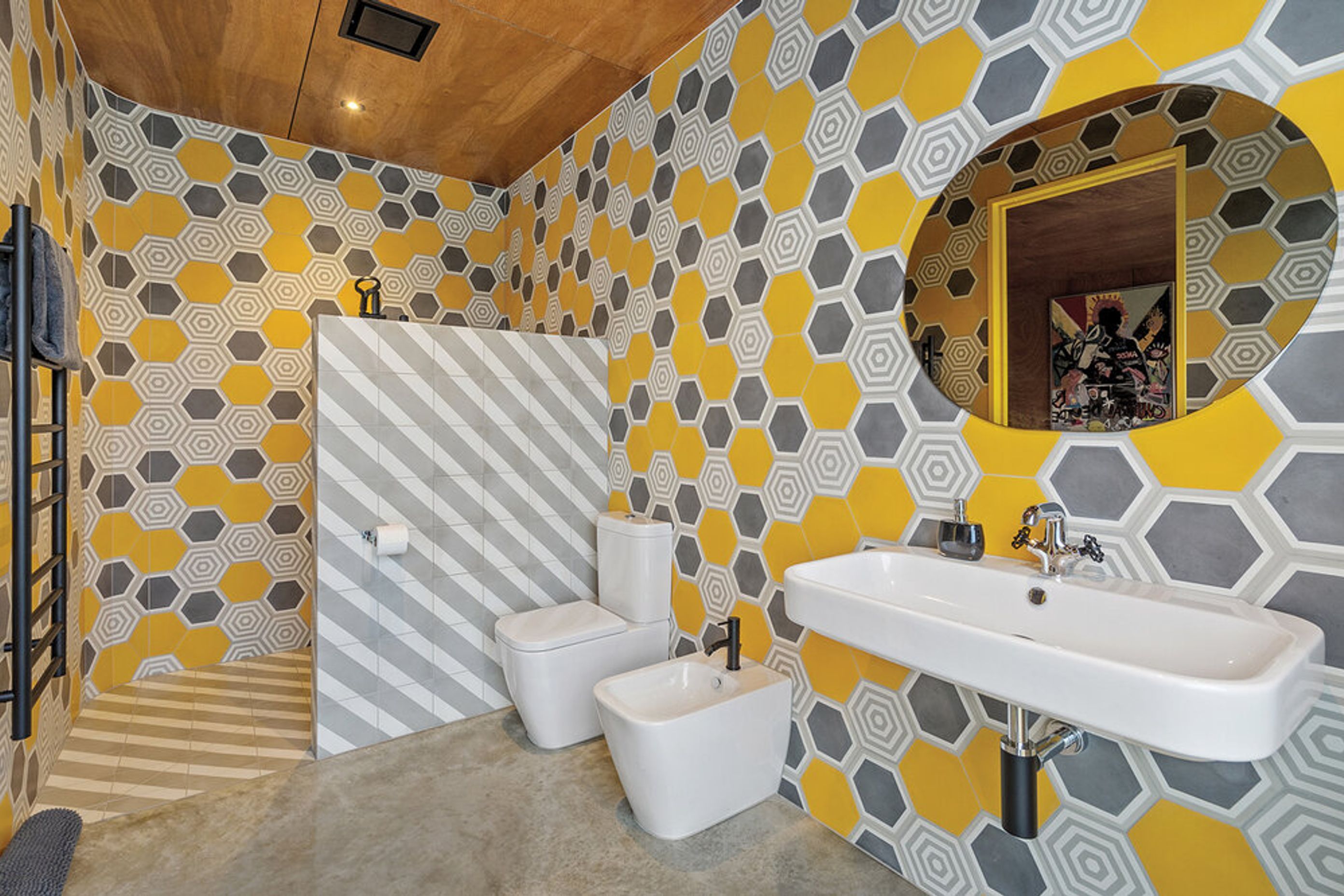 This eye-catching bathroom features a honeycomb pattern wallpaper in vibrant patterns.