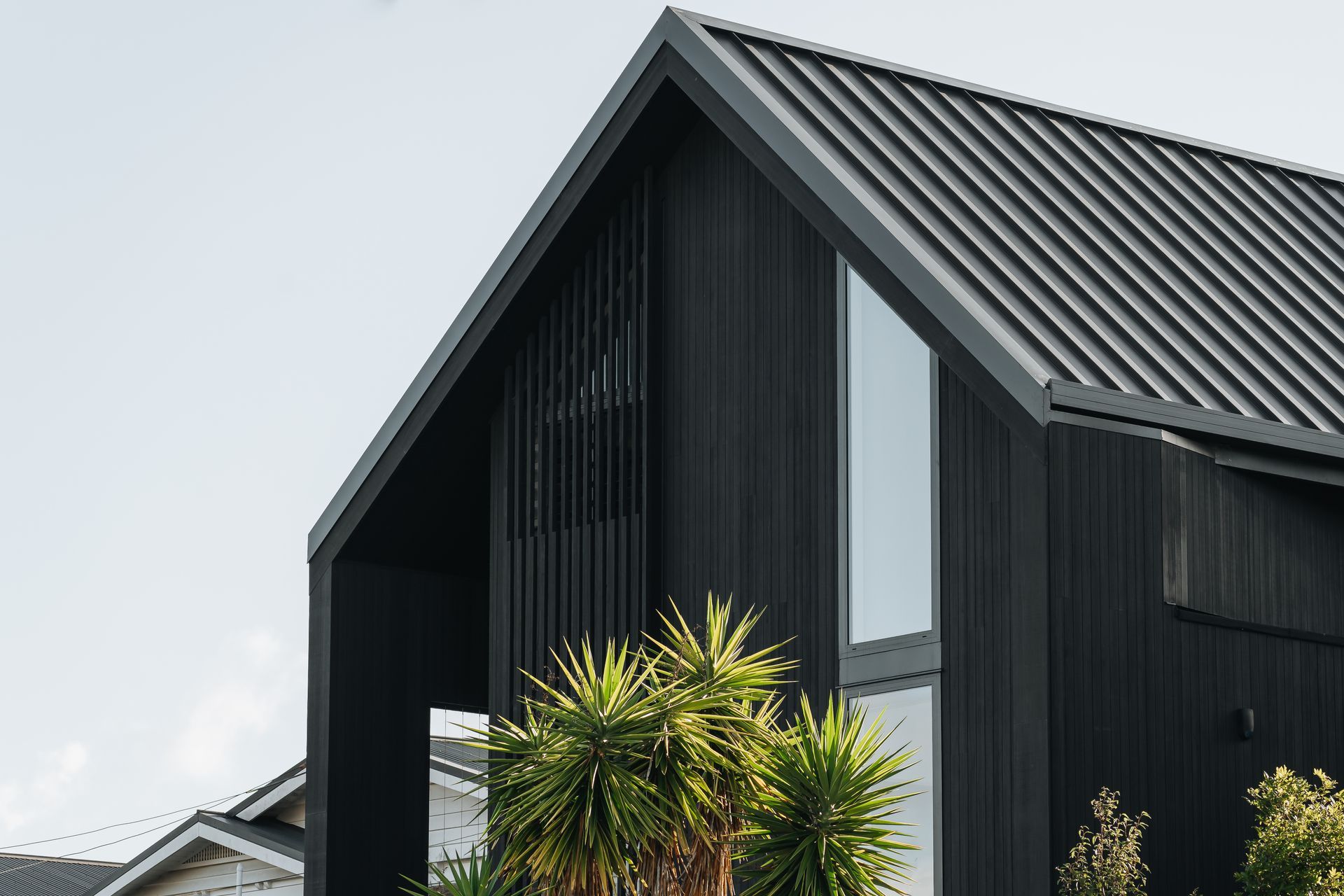 The black exterior makes a bold statement along the street in Westmere, Auckland.