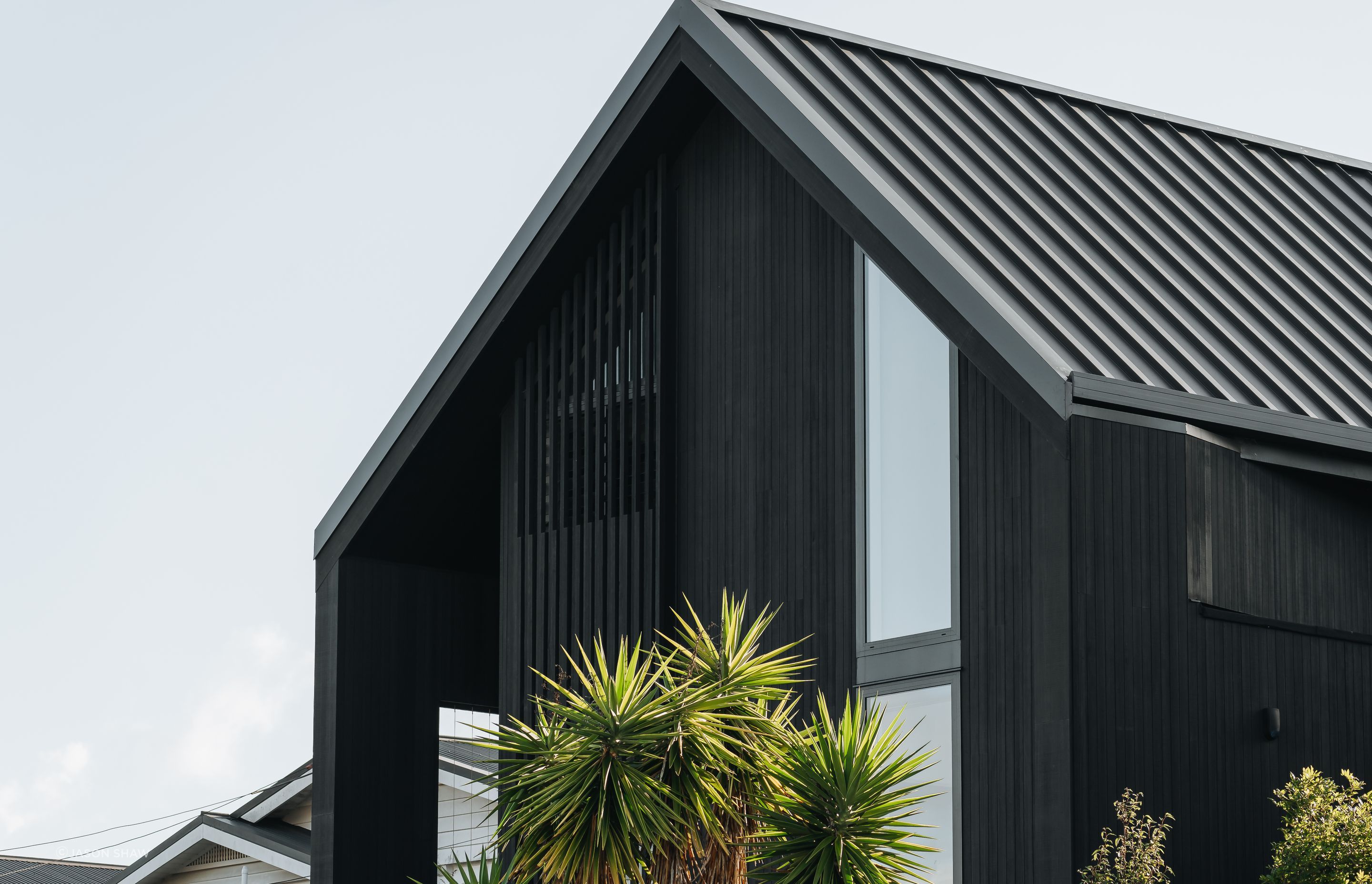The black exterior makes a bold statement along the street in Westmere, Auckland.