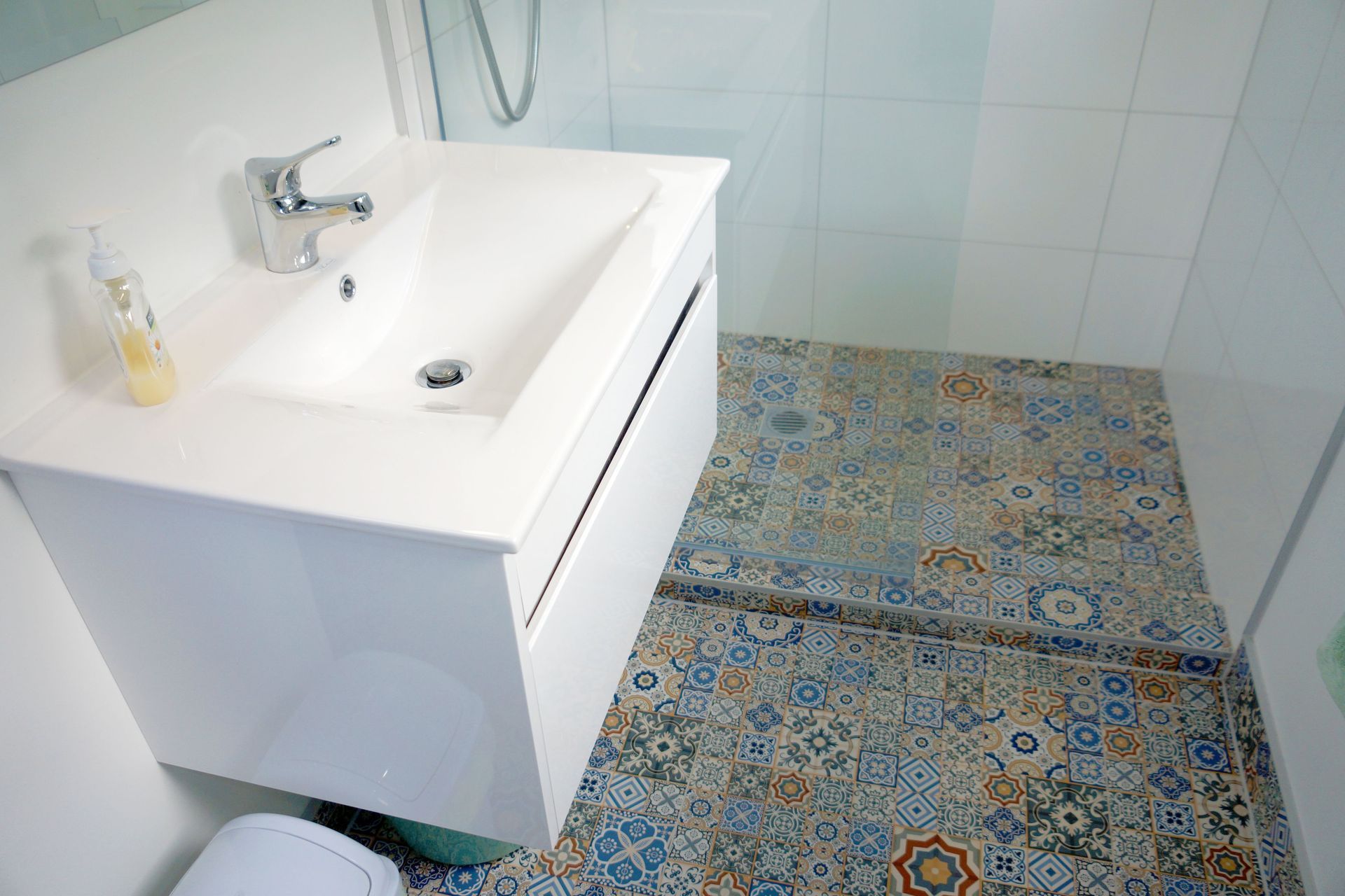 The bathroom was renovated with new fixtures, vanity, shower, and mosaic tiles. 