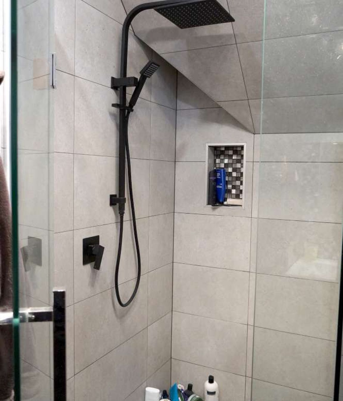 Bathroom renovation in Cockle Bay, Auckland. A shower niche was created in the wall of the tiled shower as a design feature.