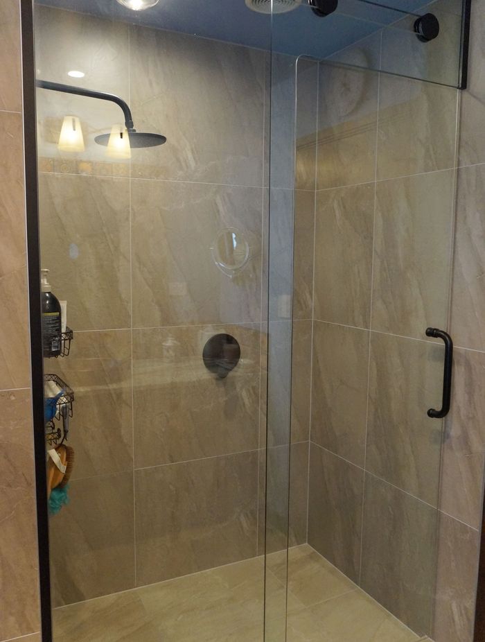 This tiled shower was renovated with a floor to ceiling glass door to make the bathroom look more open and spacious – Bathroom renovation in Stanmore Bay, Auckland