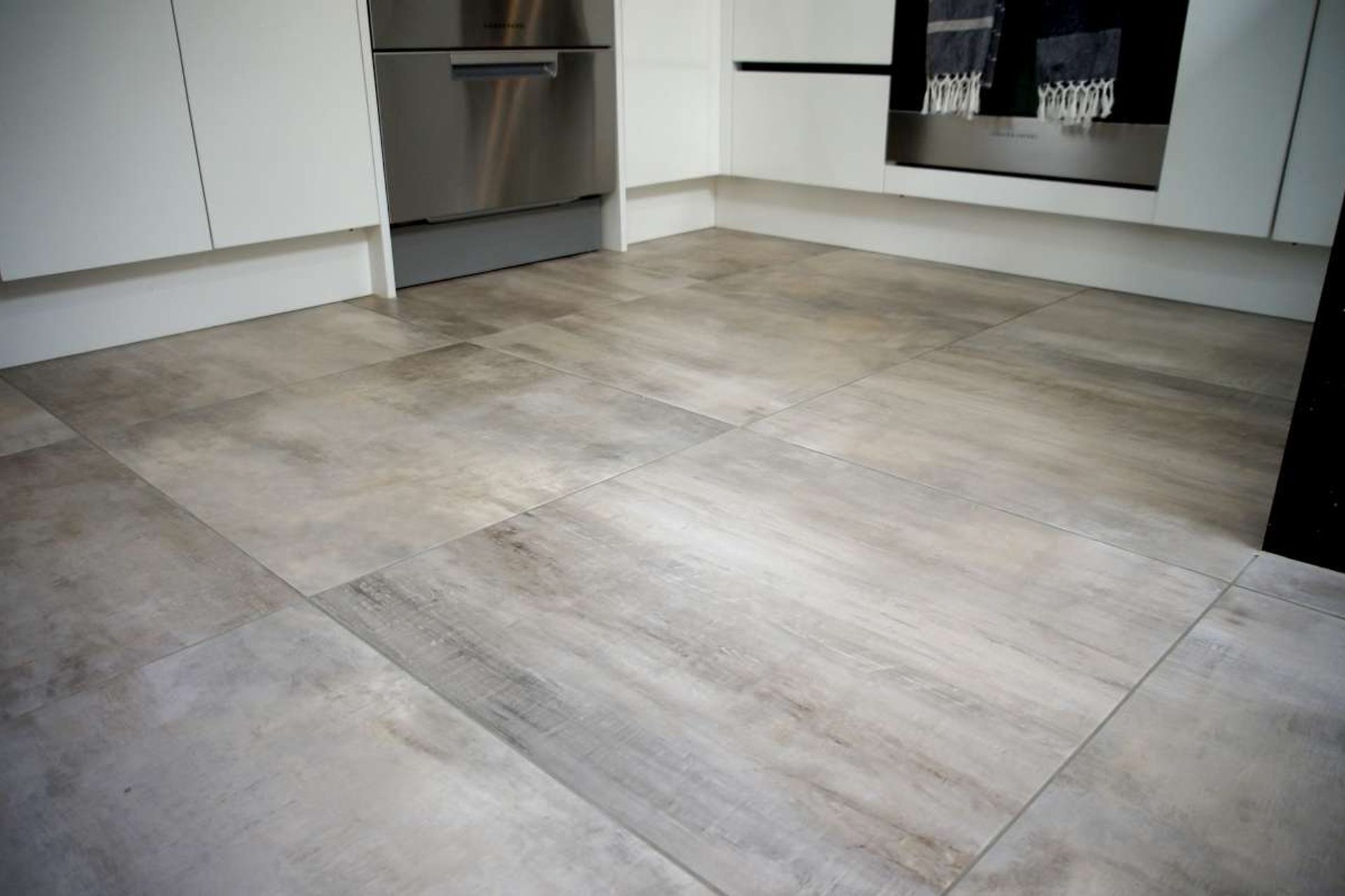 Kitchen renovation in Bucklands Beach: Ceramic tiles which mimic hardwood were installed for easy maintenance and as a cost effective option