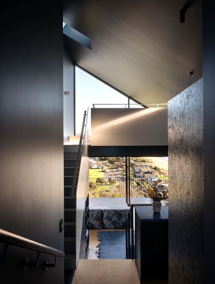 Step down from the front door into the living room, or upstairs to the mezzanine. Interior surfaces are all unified with shades of blue. “There's something nice about deeper, darker spaces,” says Dominic.