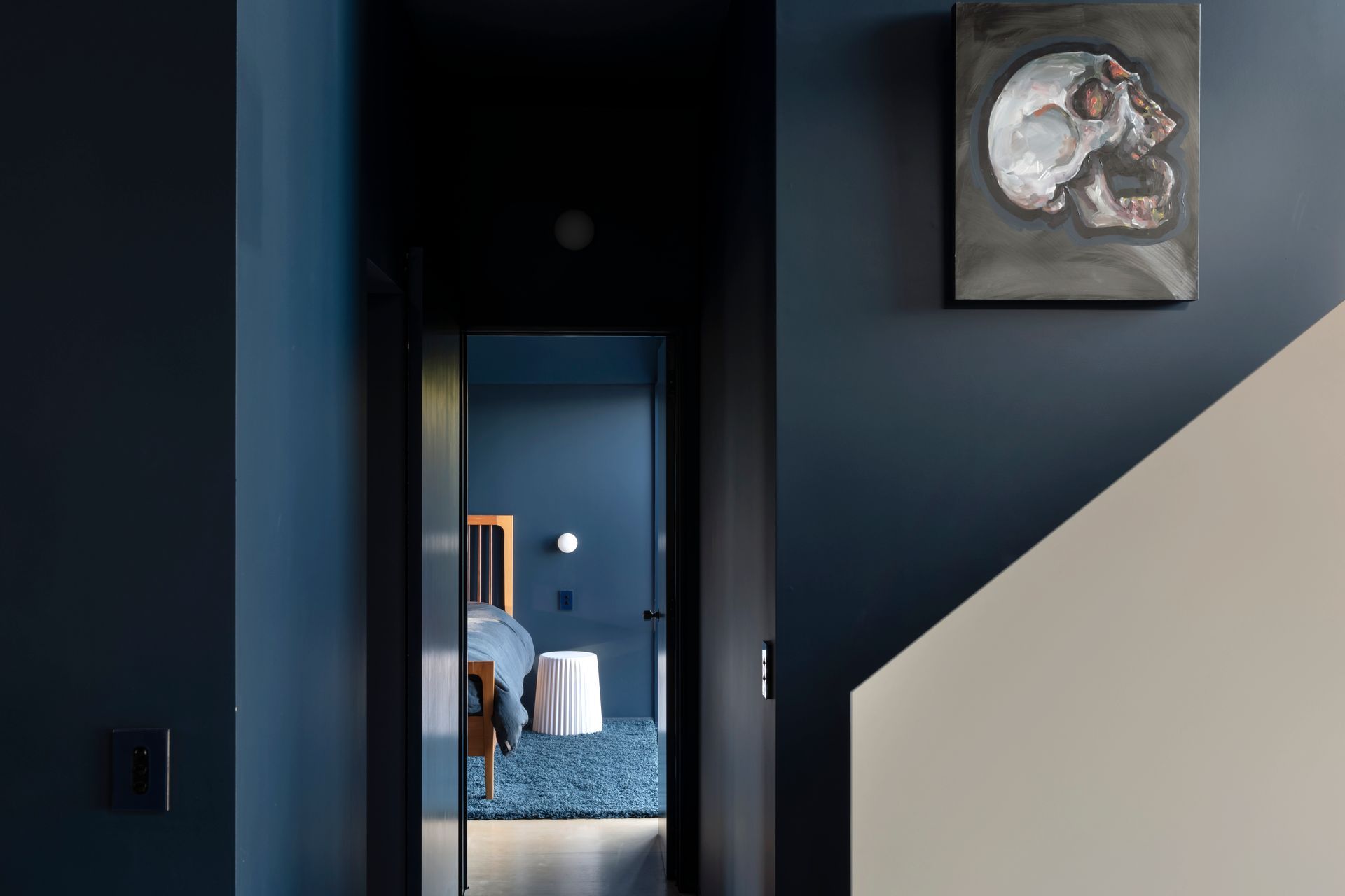 The view into the main bedroom. The bed is by Design Mobel, the rug is from iRugs and homeowner Gerry painted the artwork in the stairwell.