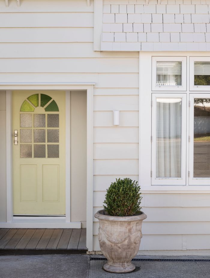The butter yellow door adds a pop of colour to the entryway. Photo: David Straight