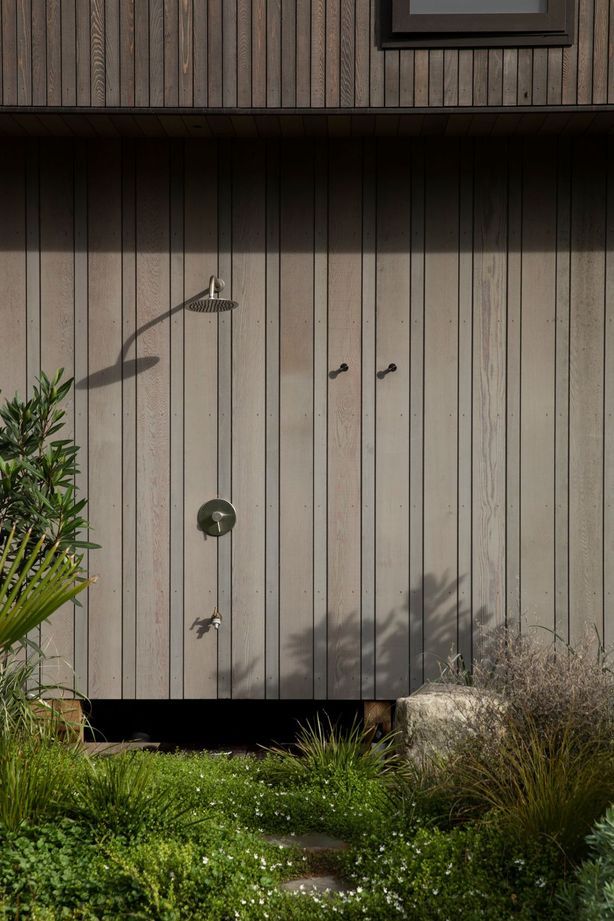 On the south side of the vertical building form, an outdoor shower is tucked away. Image credit: David Straight