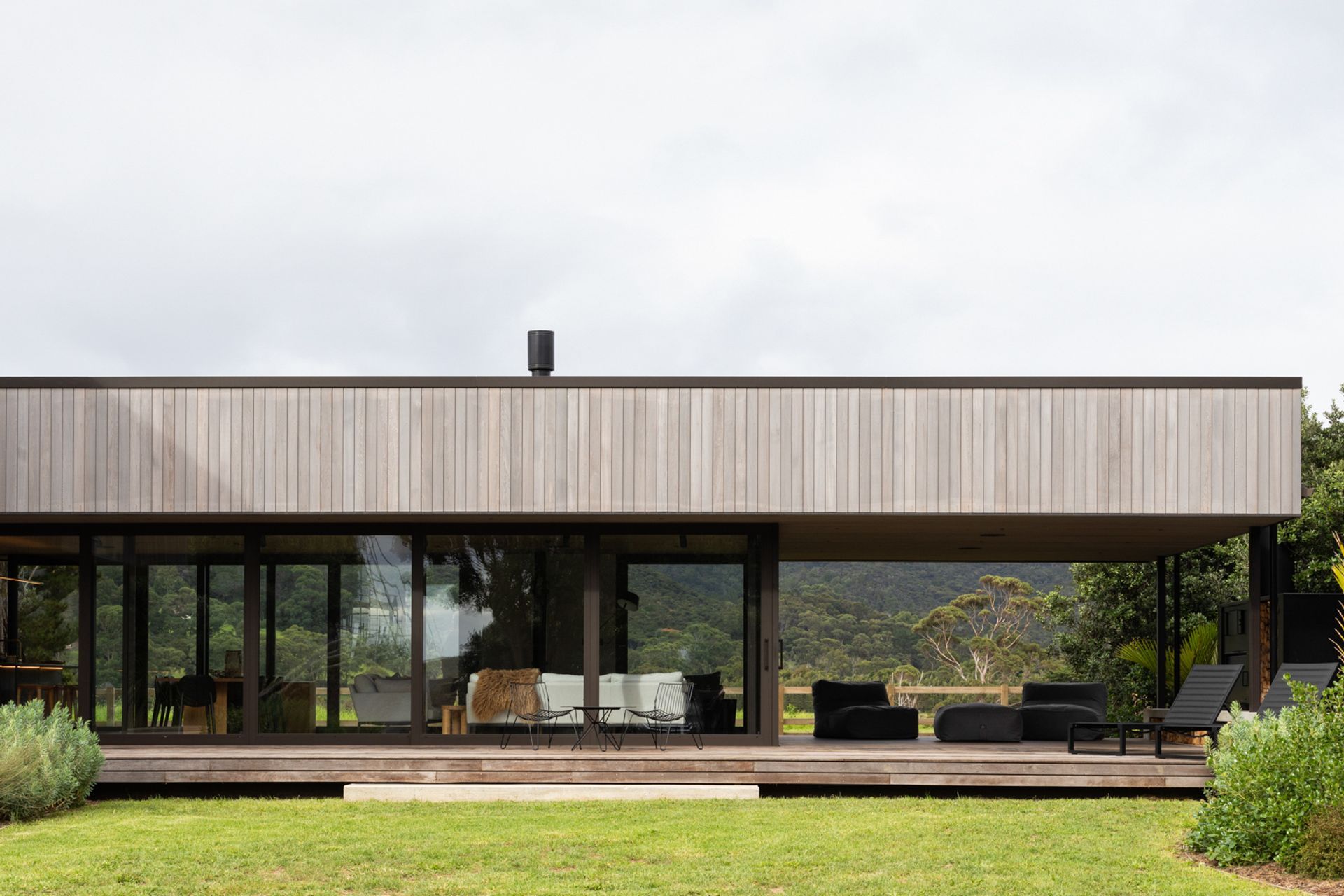 The low-lying form containing the main living space and kitchen extends out to encompass a sheltered outdoor living area. Image credit: David Straight