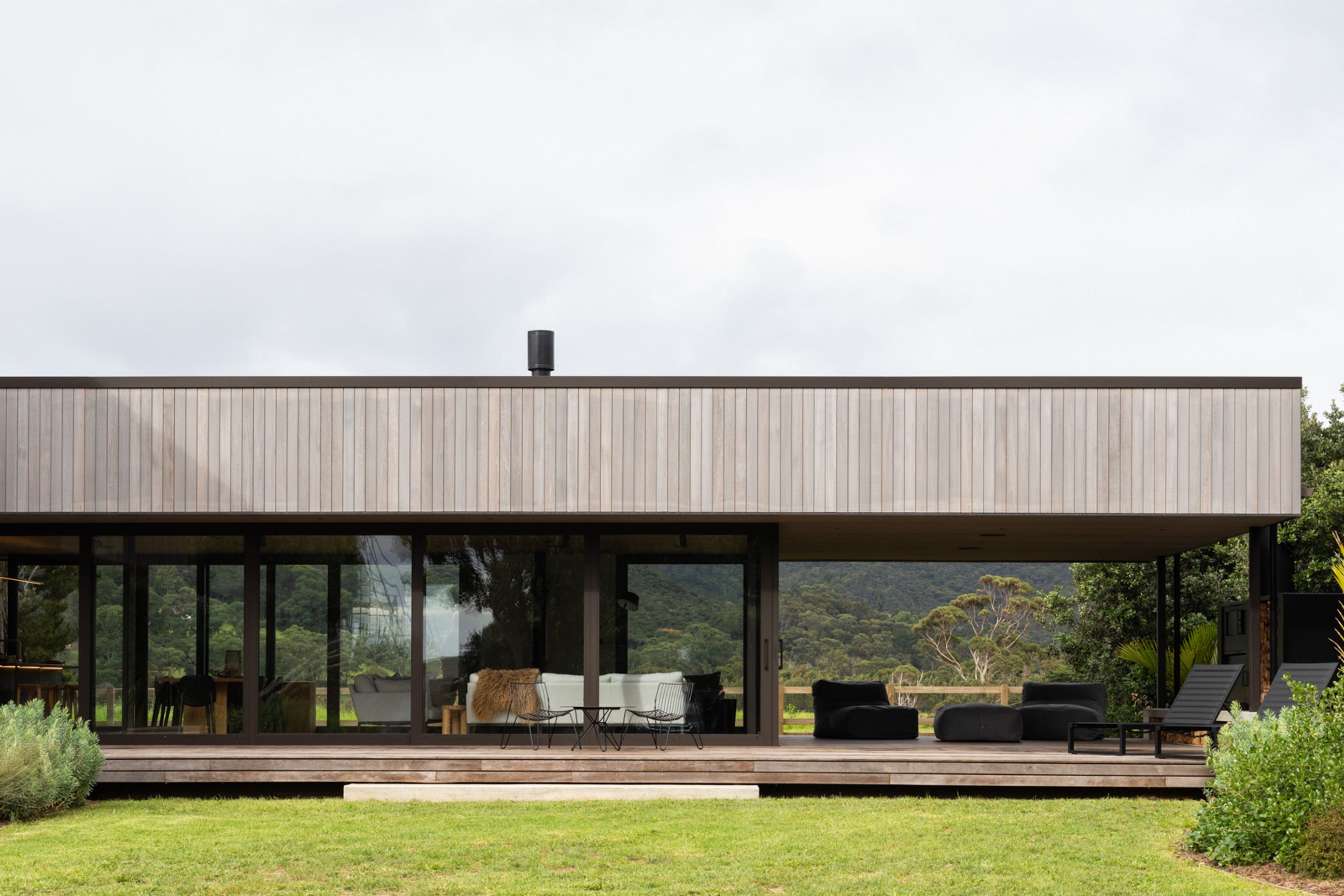 The low-lying form containing the main living space and kitchen extends out to encompass a sheltered outdoor living area. Image credit: David Straight