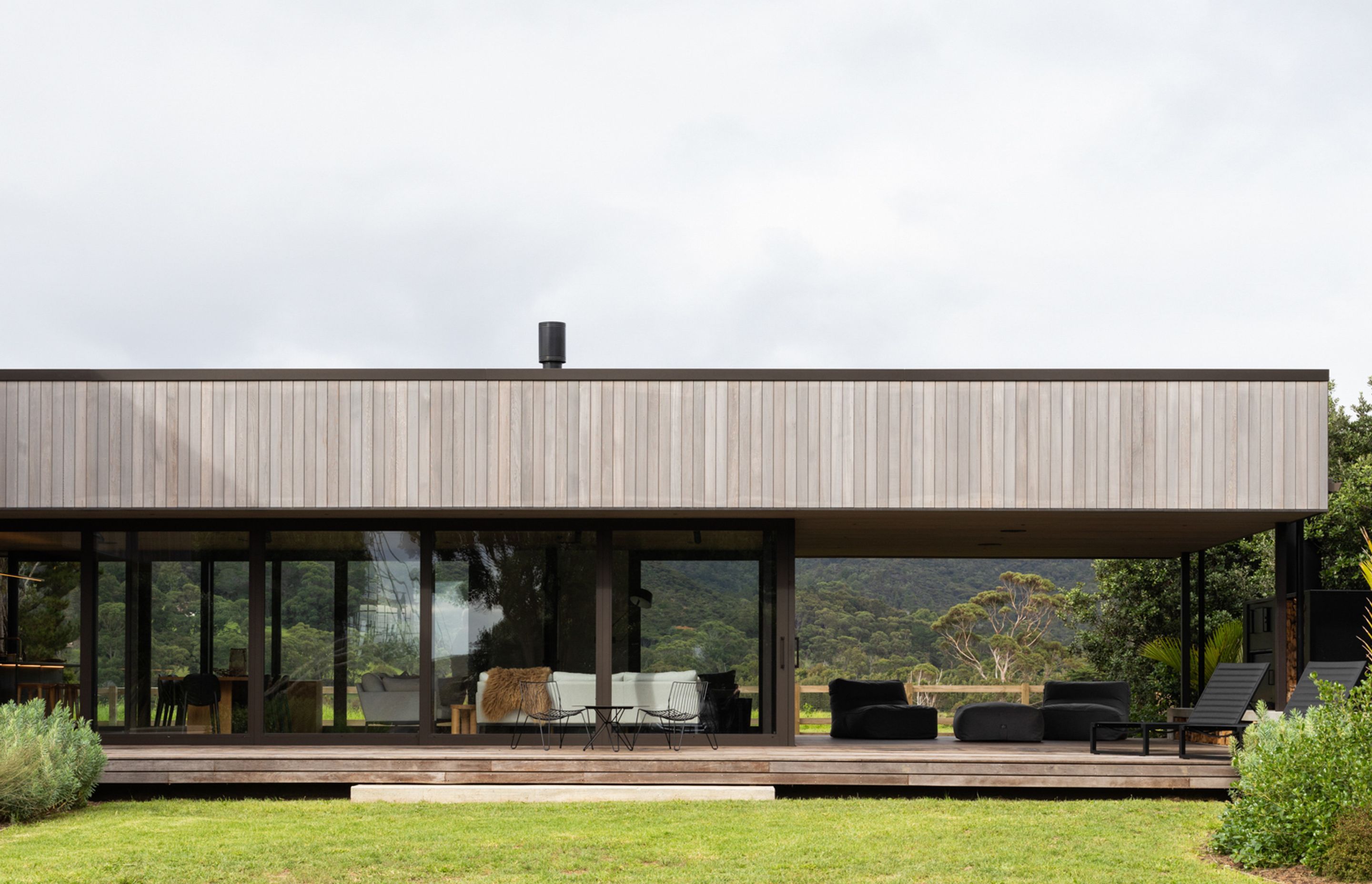 The low-lying form containing the main living space and kitchen extends out to encompass a sheltered outdoor living area. Image credit: David Straight