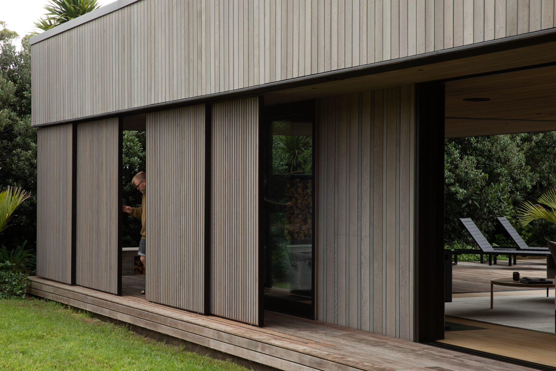 Cedar screens can be moved to screen the outdoor living space from rain, sun and wind. Image credit: David Straight