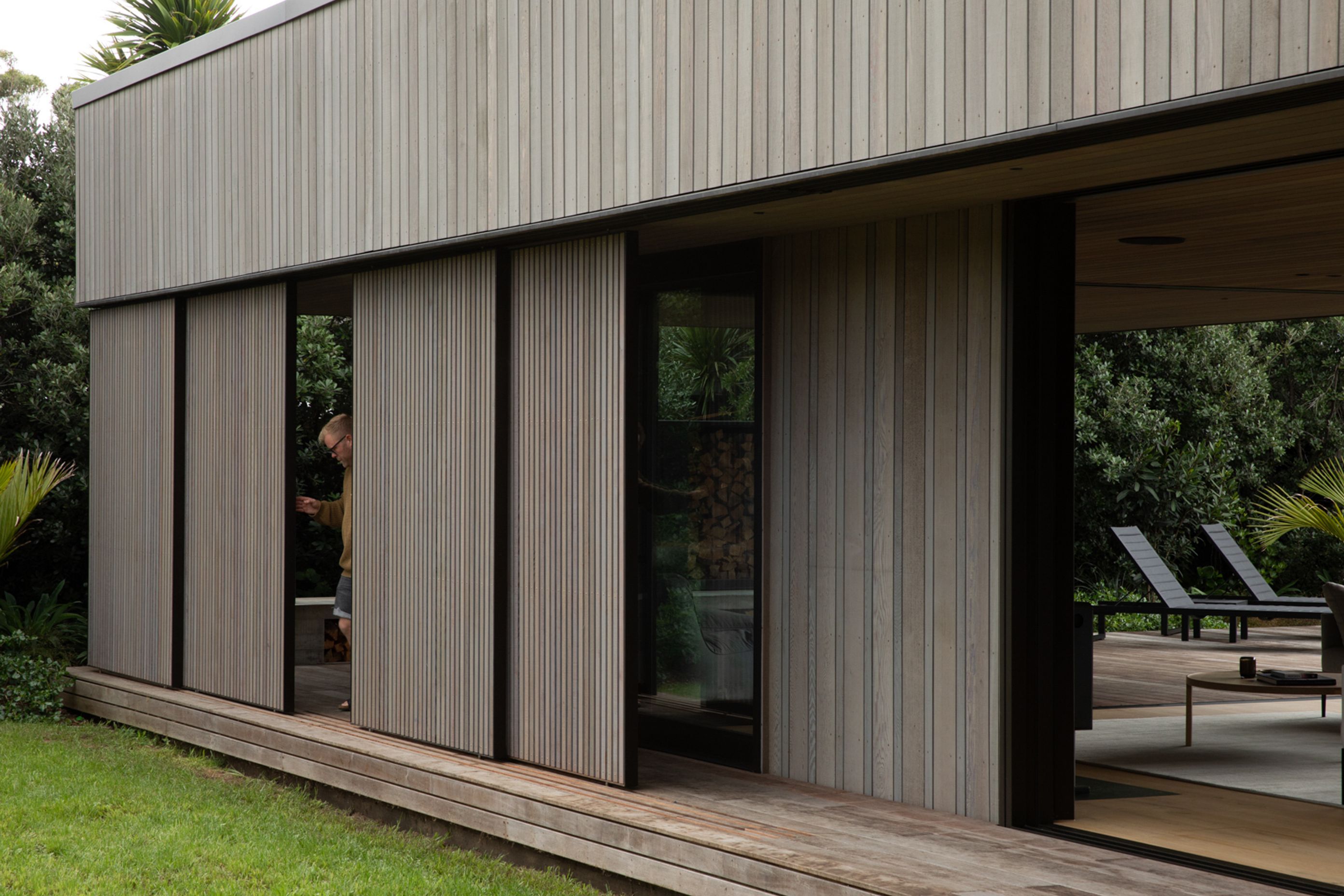 Cedar screens can be moved to screen the outdoor living space from rain, sun and wind. Image credit: David Straight
