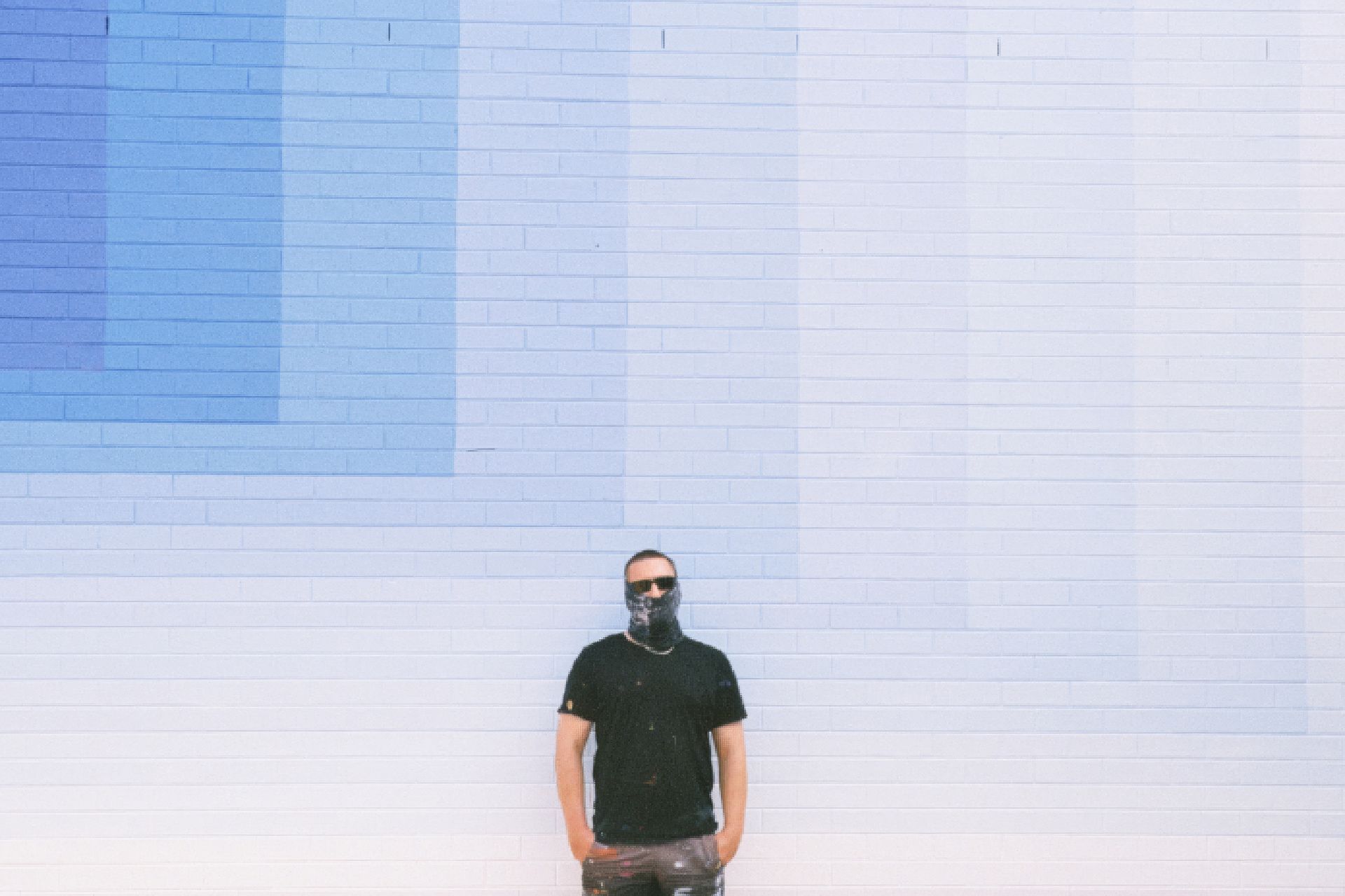 Melbourne street artist Drez stands in front of a mural he created for the Benalla Street Art Festival.