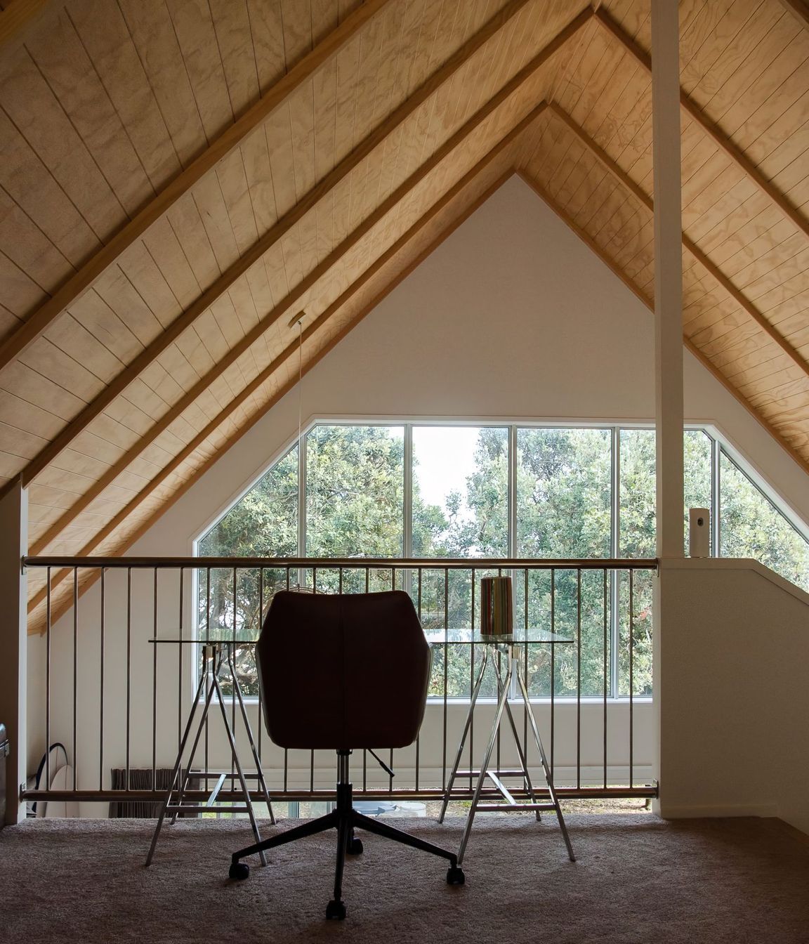 The exposed timber ceiling brings an alpine cabin feel to this Baylys Beach getaway.