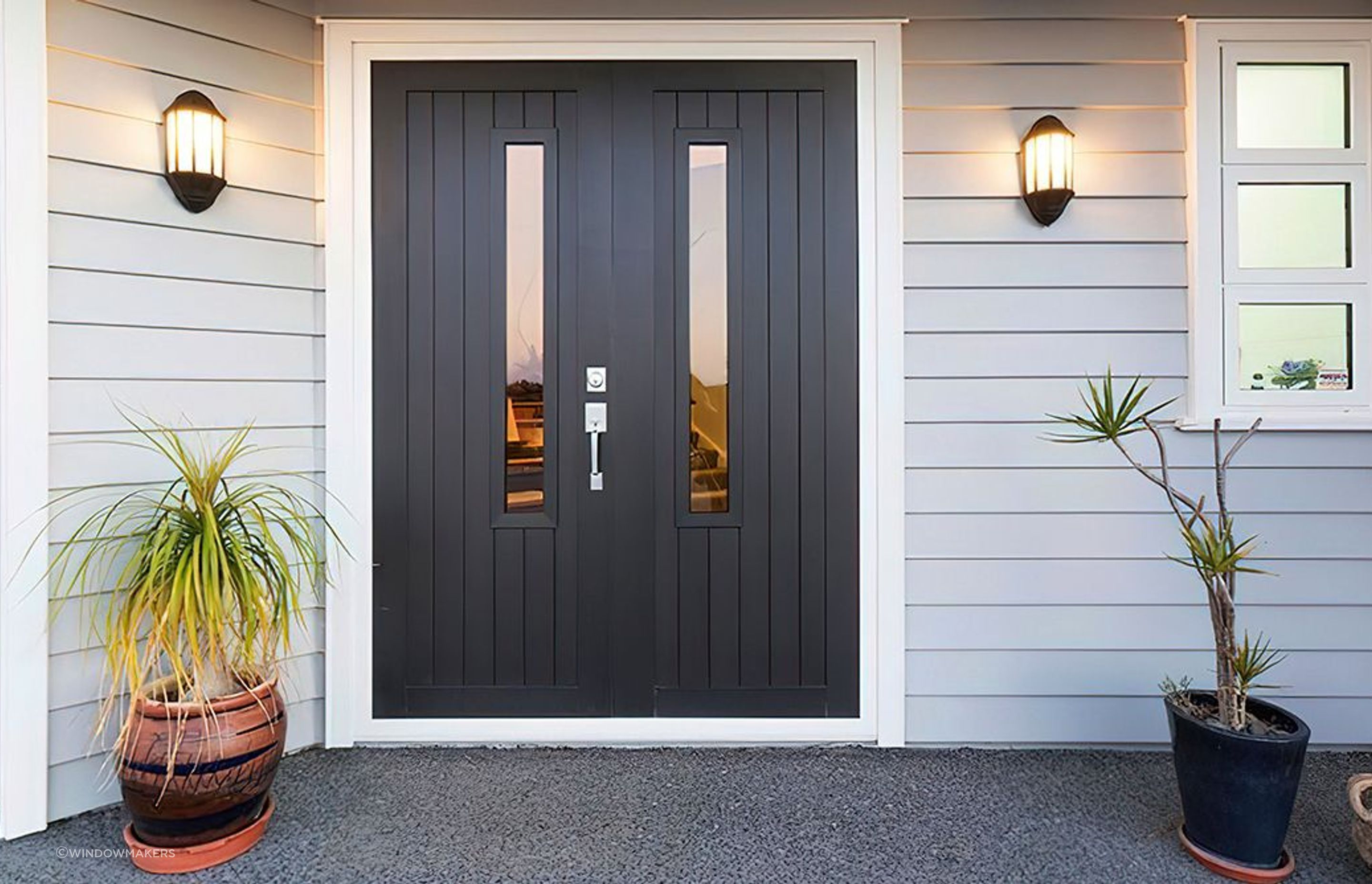 Wall sconces add illumination and style to this front door entrance area featuring the Latitude Entrance Doors