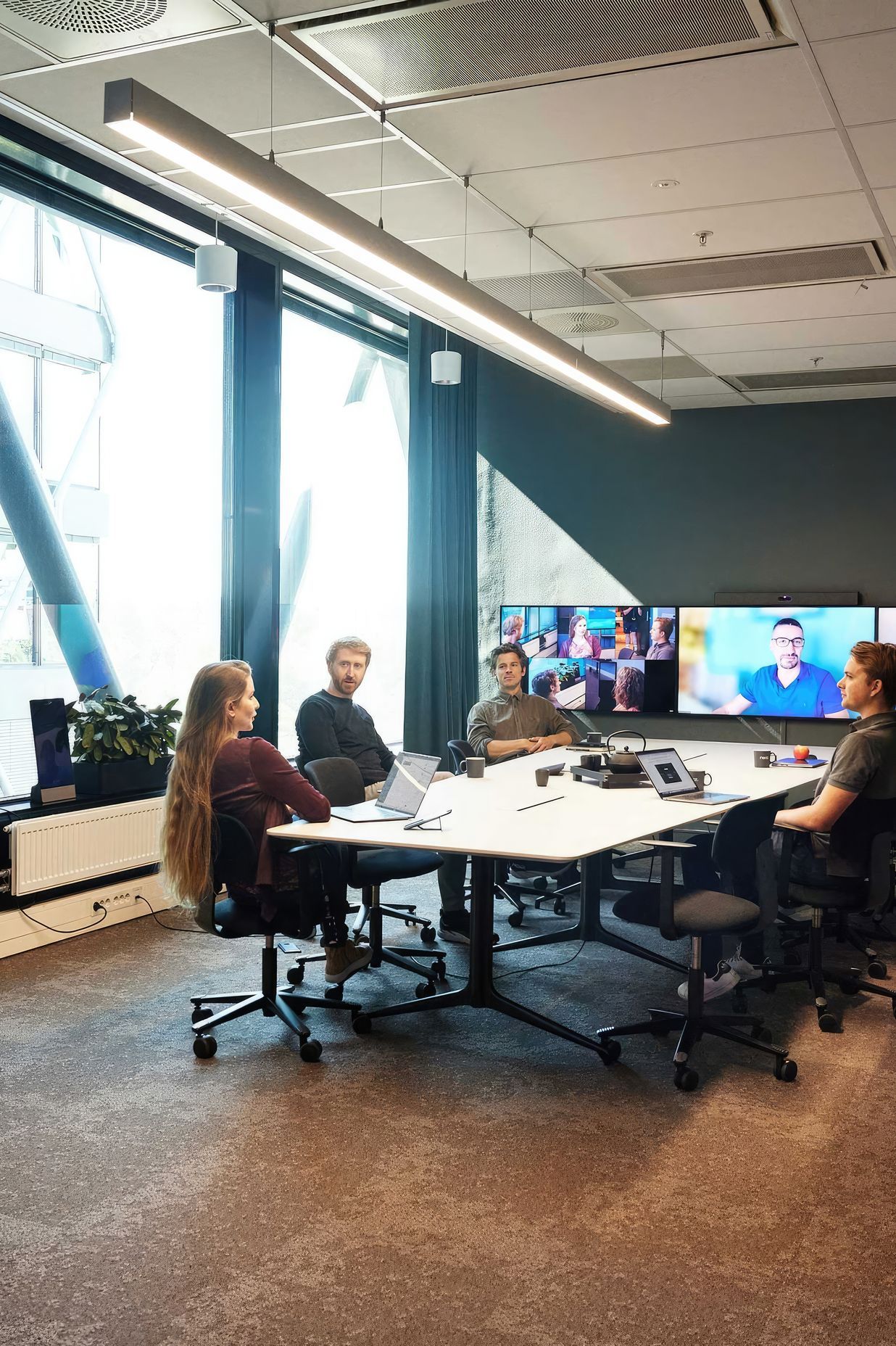 Hayley Cannon: "Neat Symmetry is our patented technology combining advanced AI with a high-resolution sensor that detects everyone in the meeting room, zooming in to individually pinpoint and auto-frame each person, then presenting them up close on remote participants’ screens. | Featured Flokk design: HÅG Tion 2160