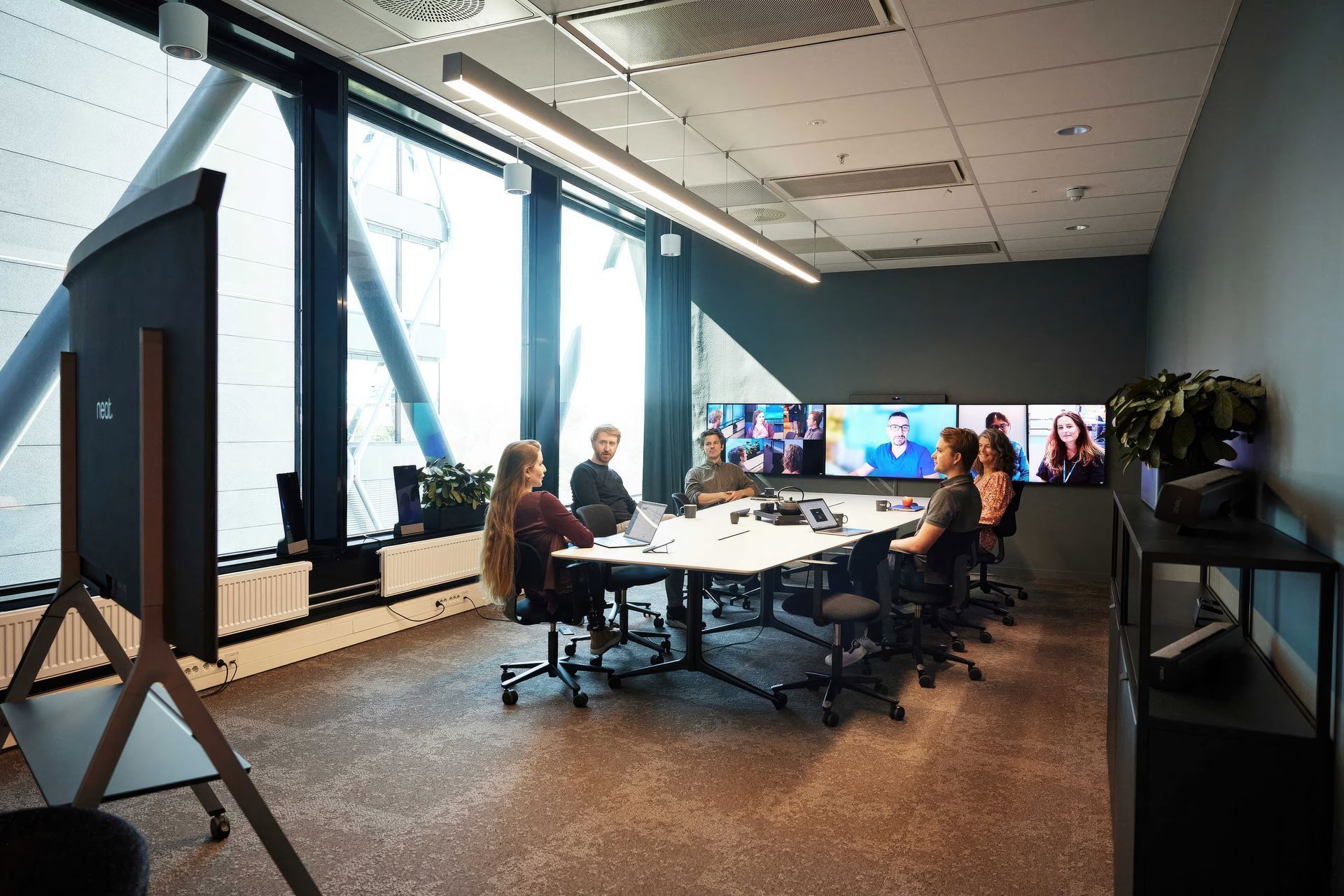 Hayley Cannon: "Neat Symmetry is our patented technology combining advanced AI with a high-resolution sensor that detects everyone in the meeting room, zooming in to individually pinpoint and auto-frame each person, then presenting them up close on remote participants’ screens. | Featured Flokk design: HÅG Tion 2160