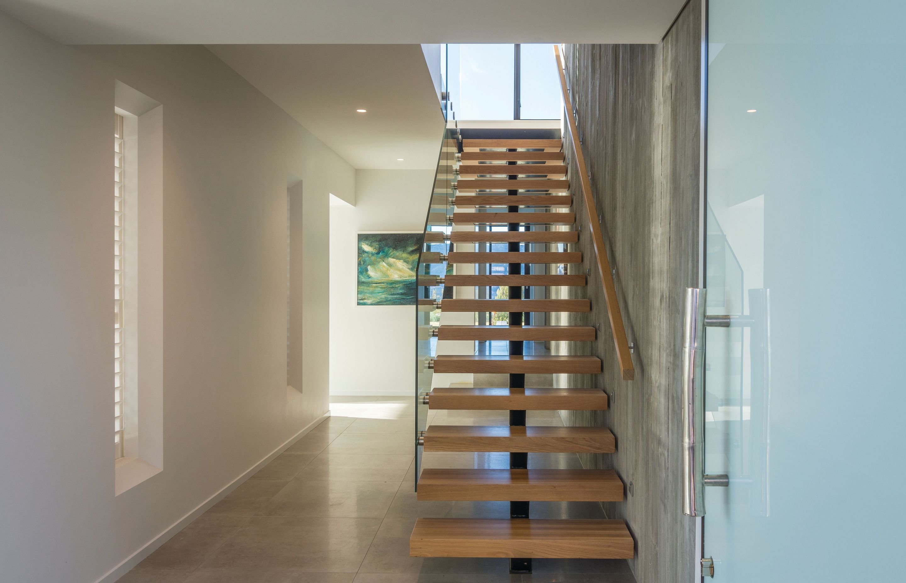 Frameless glass balustrades flanking a staircase.