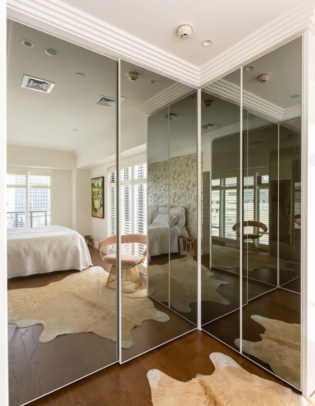 This interior by Stratford Interior Design showcases smokey glass mirrored doors, which contrast nicely against the white frames and traditional mouldings in this apartment: "This was in a very small apartment and  having that dark mirror on the wardrobes really created the illusion of space," says Gina.