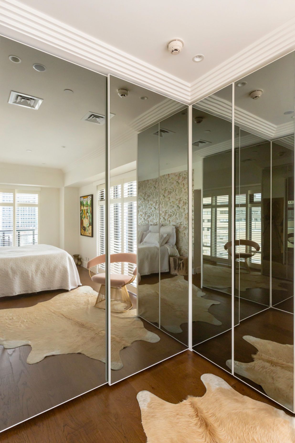 This interior by Stratford Interior Design showcases smokey glass mirrored doors, which contrast nicely against the white frames and traditional mouldings in this apartment: "This was in a very small apartment and  having that dark mirror on the wardrobes really created the illusion of space," says Gina.