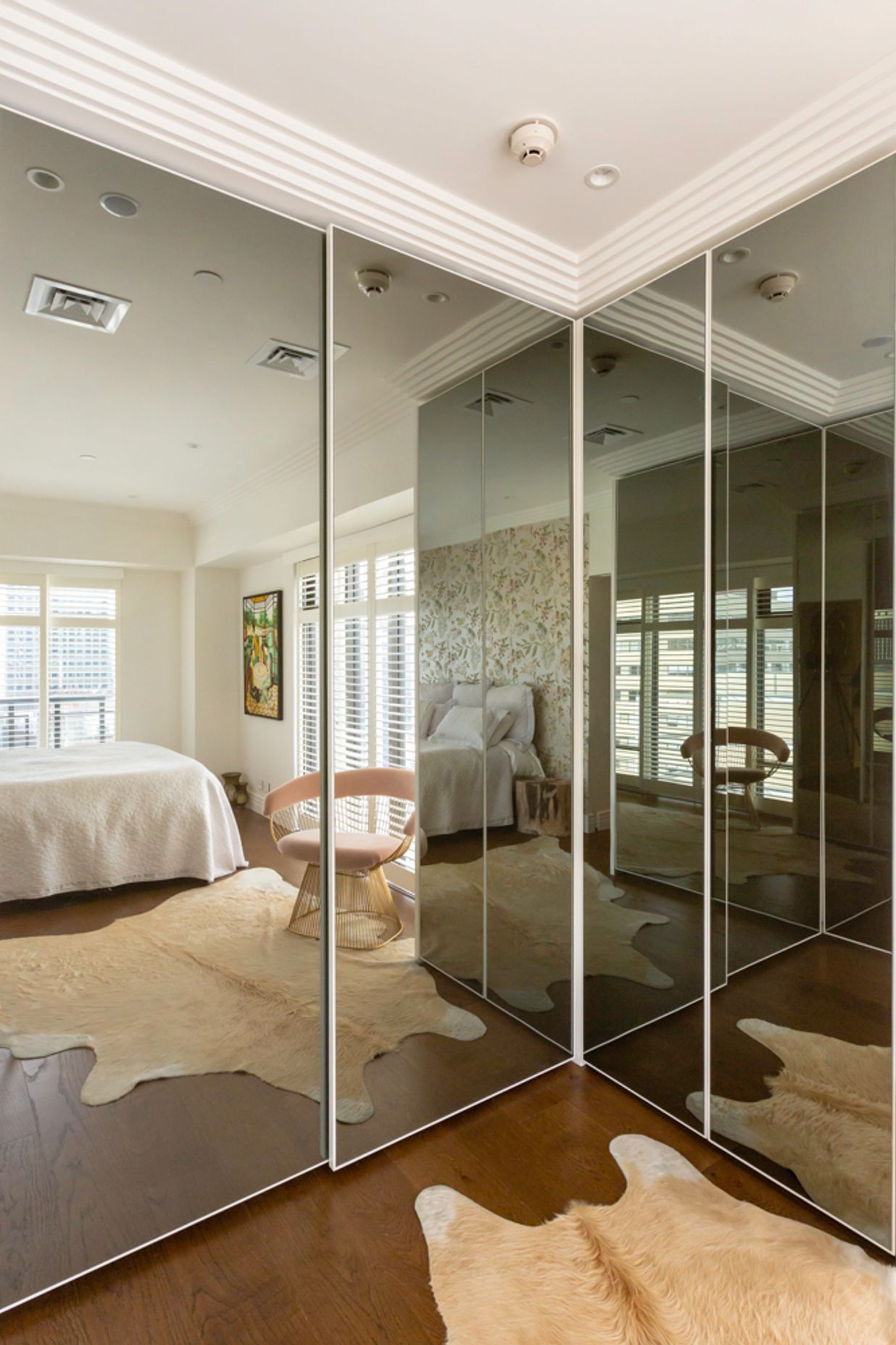 This interior by Stratford Interior Design showcases smokey glass mirrored doors, which contrast nicely against the white frames and traditional mouldings in this apartment: "This was in a very small apartment and having that dark mirror on the wardrobes really created the illusion of space," says Gina.