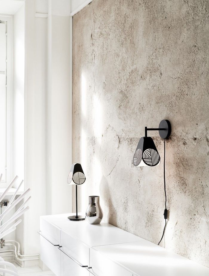 The Oblure Notic Collection lighting pieces add graphic, textural design elements to a space with simple black forms and opaline diffusers. Add definition to a soft, serene space with some simple, strong details like this pair of table and wall lamps.