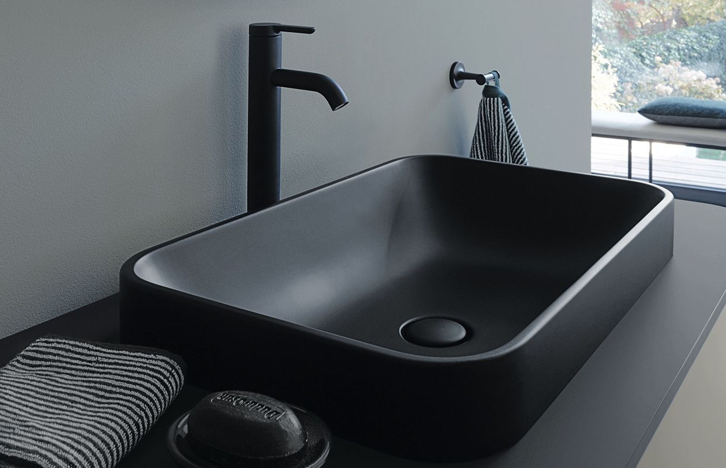 A matte black basin and tap combo add a sleek touch to this modern bathroom.