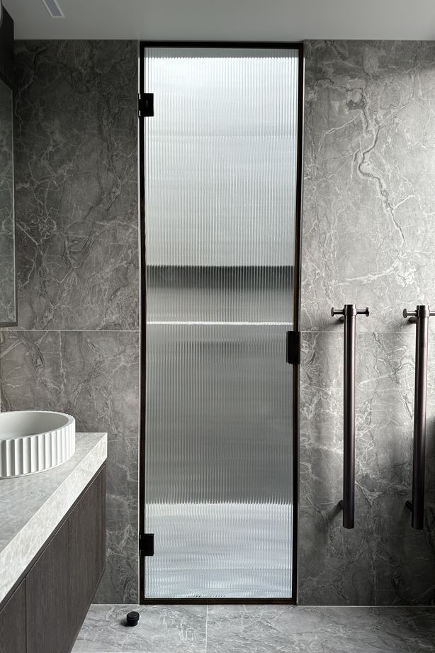 The reeded glass shower door is a beautiful, modern touch in this bathroom.