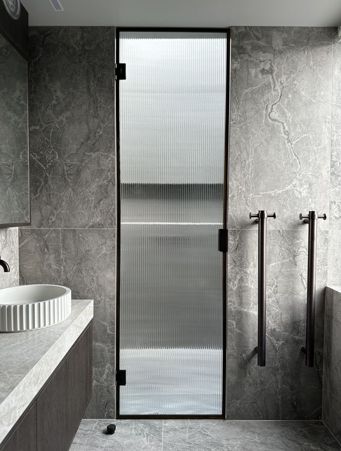 The reeded glass shower door is a beautiful, modern touch in this bathroom.