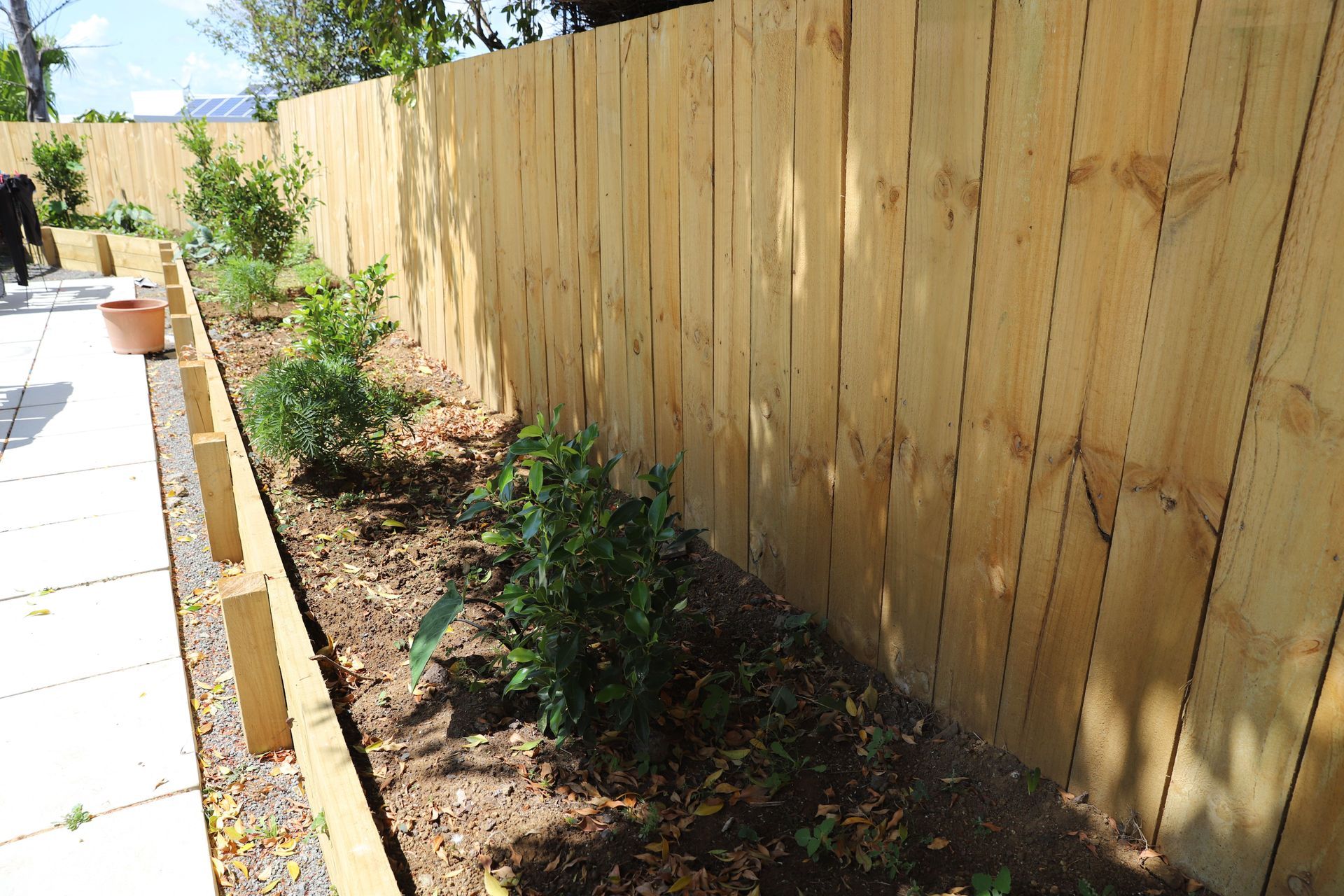 The vegetable garden surrounds the concrete patio with Timber fencing throughout.