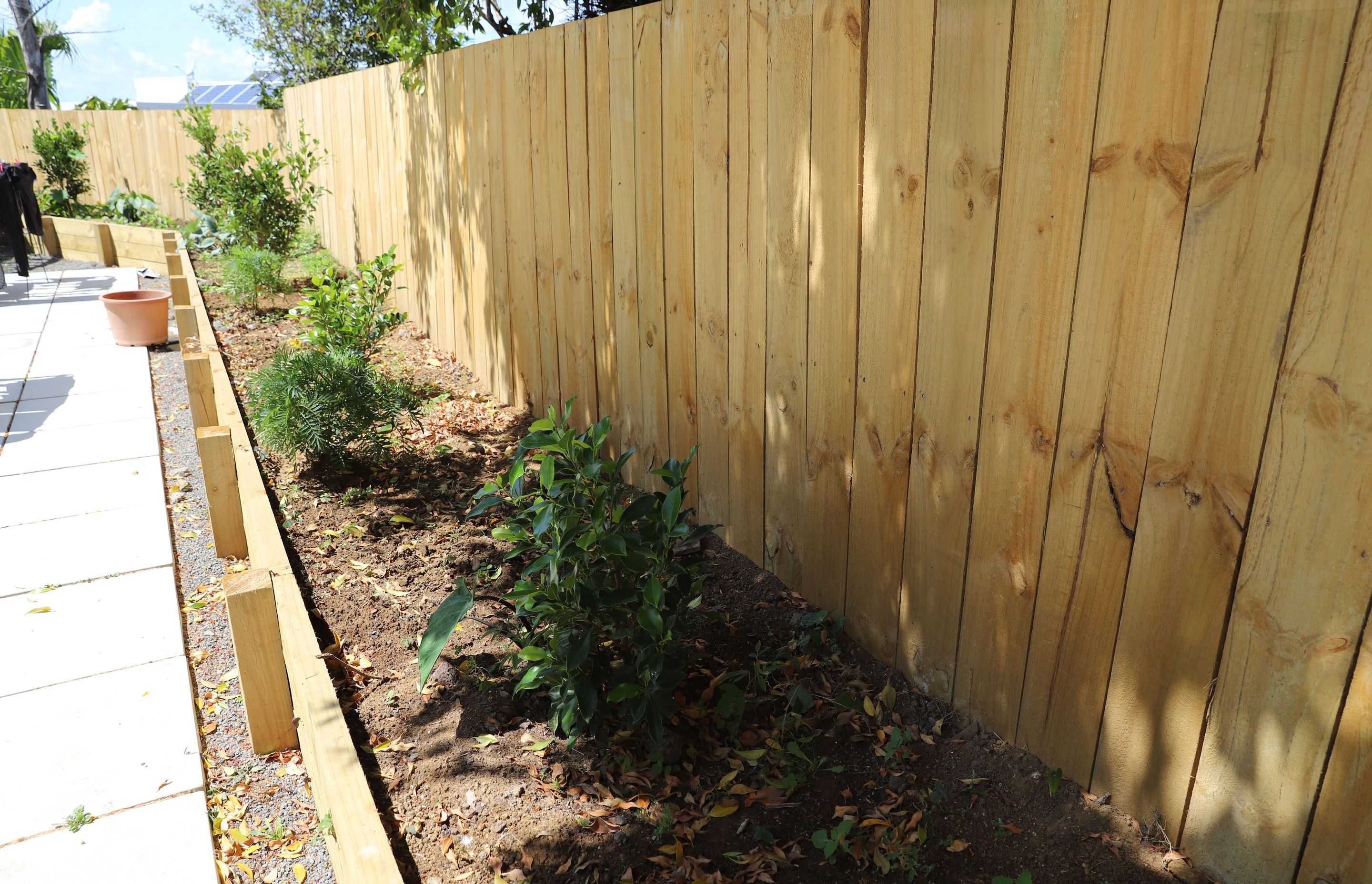 The vegetable garden surrounds the concrete patio with Timber fencing throughout.