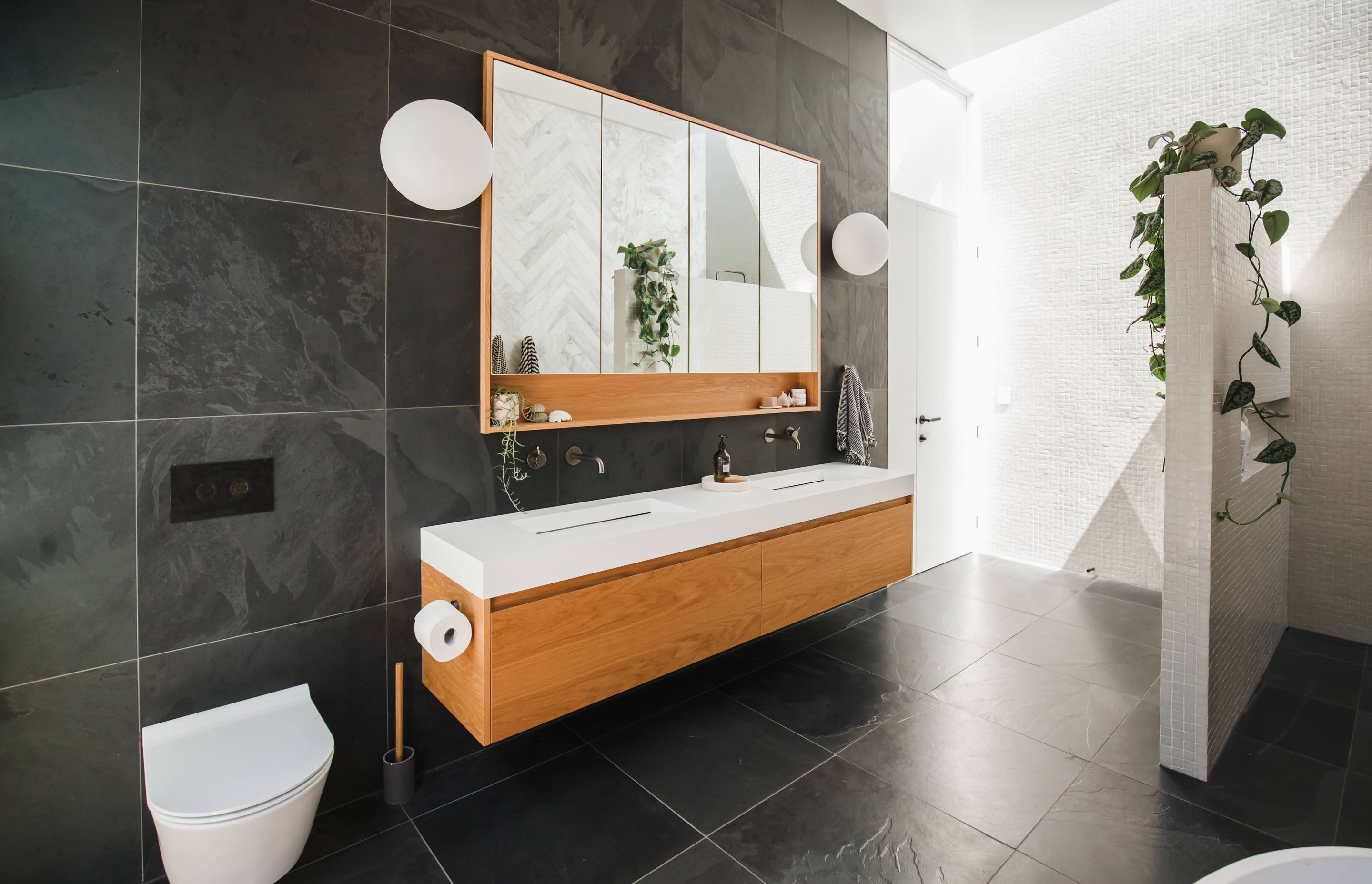 The main bathroom features a combination of slate, hone marble, and glass mosaic tiles.