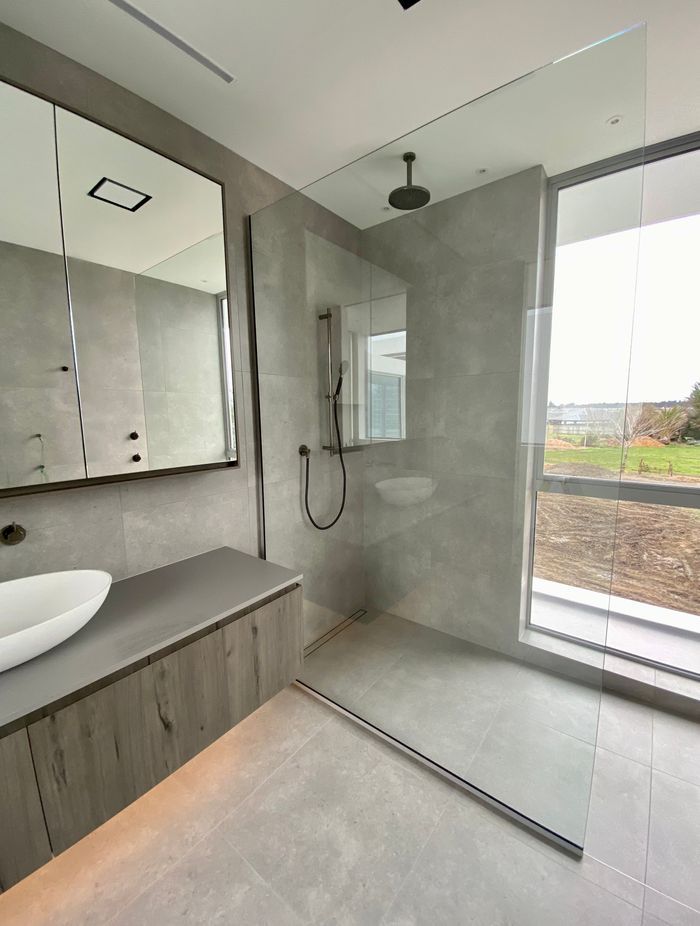 Rather than close the shower off, the designer has opted for a fixed panel shower screen that allows the light to flow freely.