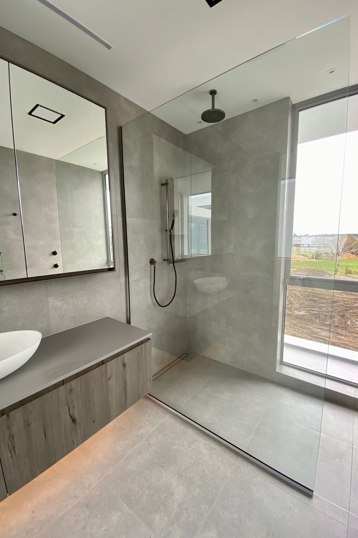 Rather than close the shower off, the designer has opted for a fixed panel shower screen that allows the light to flow freely.