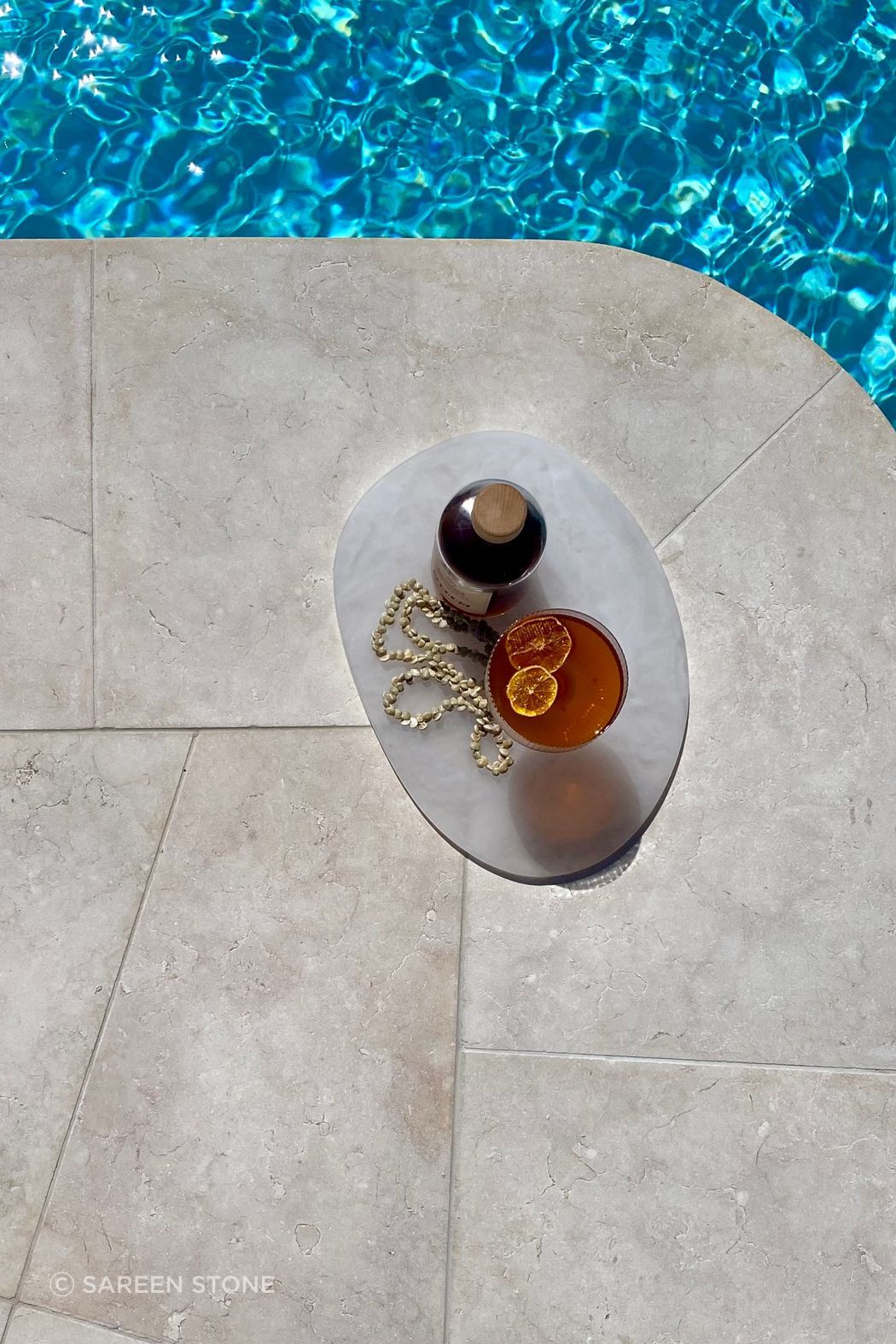 Tweed Heads Riverside Oasis by ILKA Interior Design Studio. Crema Vialle Limestone in Alfresco finish transforms this 130m² pool and spa with curved coping and precise craftsmanship by ILK Tiling. A serene 2025 outdoor retreat showcasing exceptional stone installation.