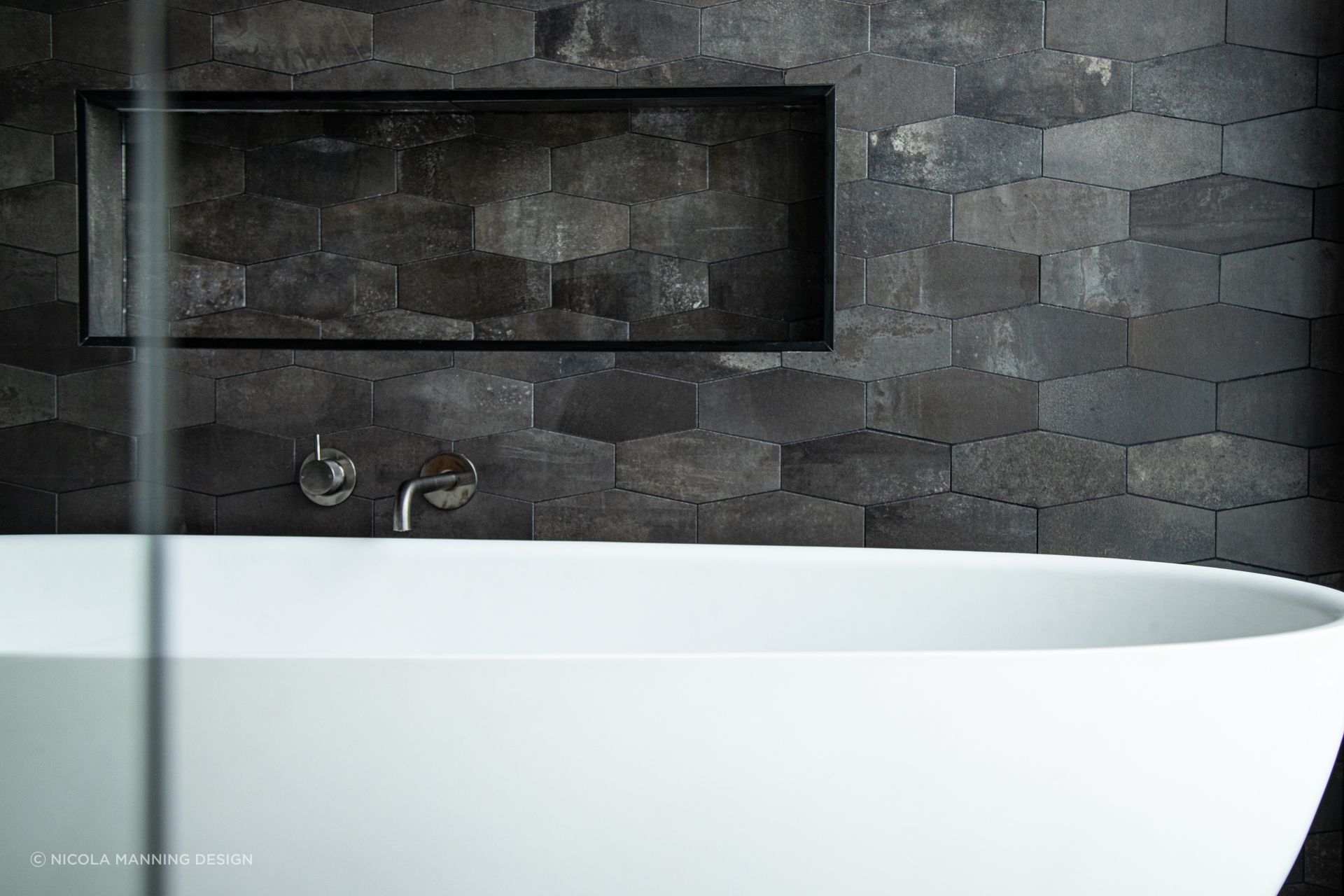 Elongated hexagons define the space around this tub in this inner city townhouse.
