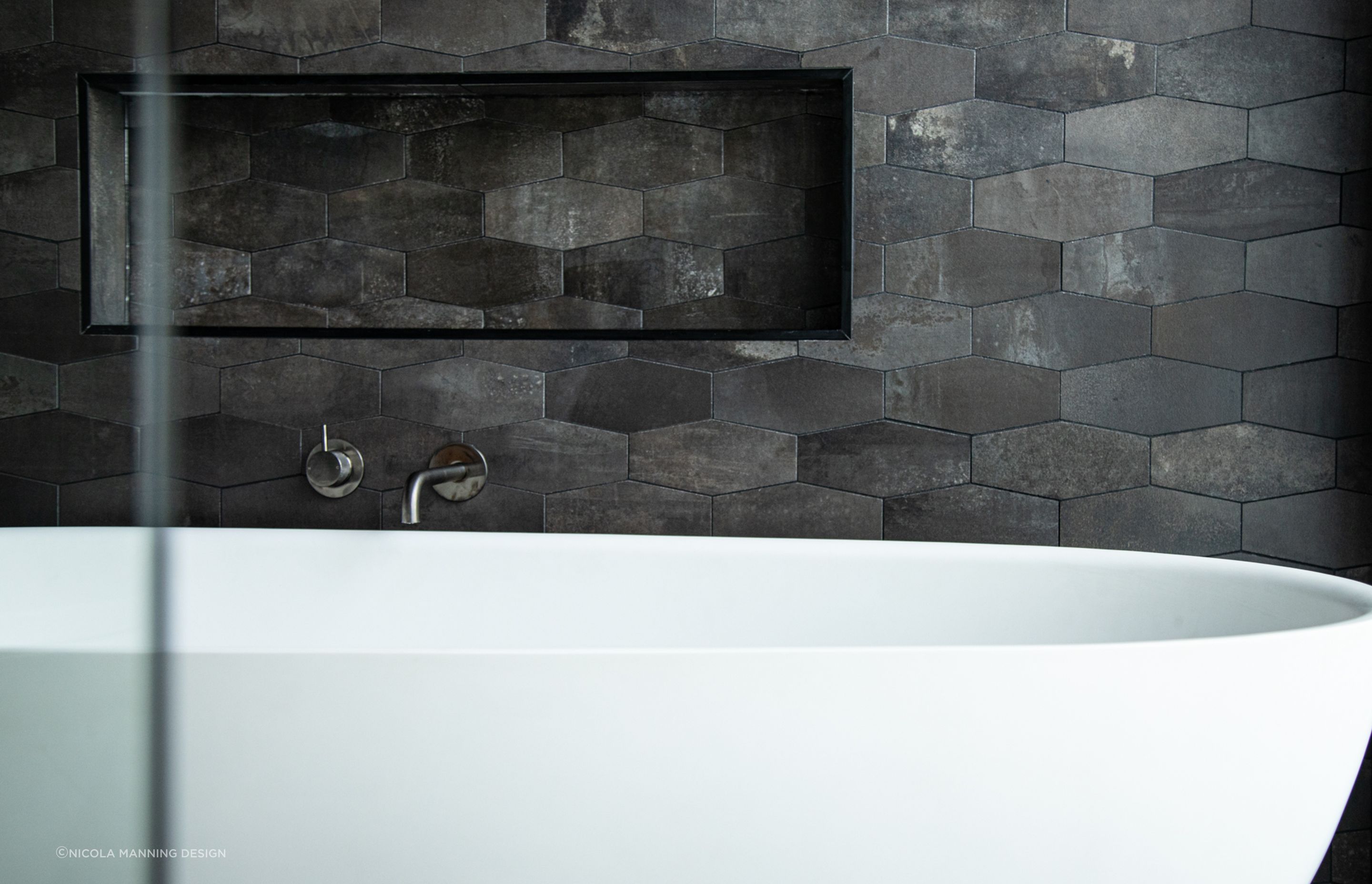 Elongated hexagons define the space around this tub in this inner city townhouse.