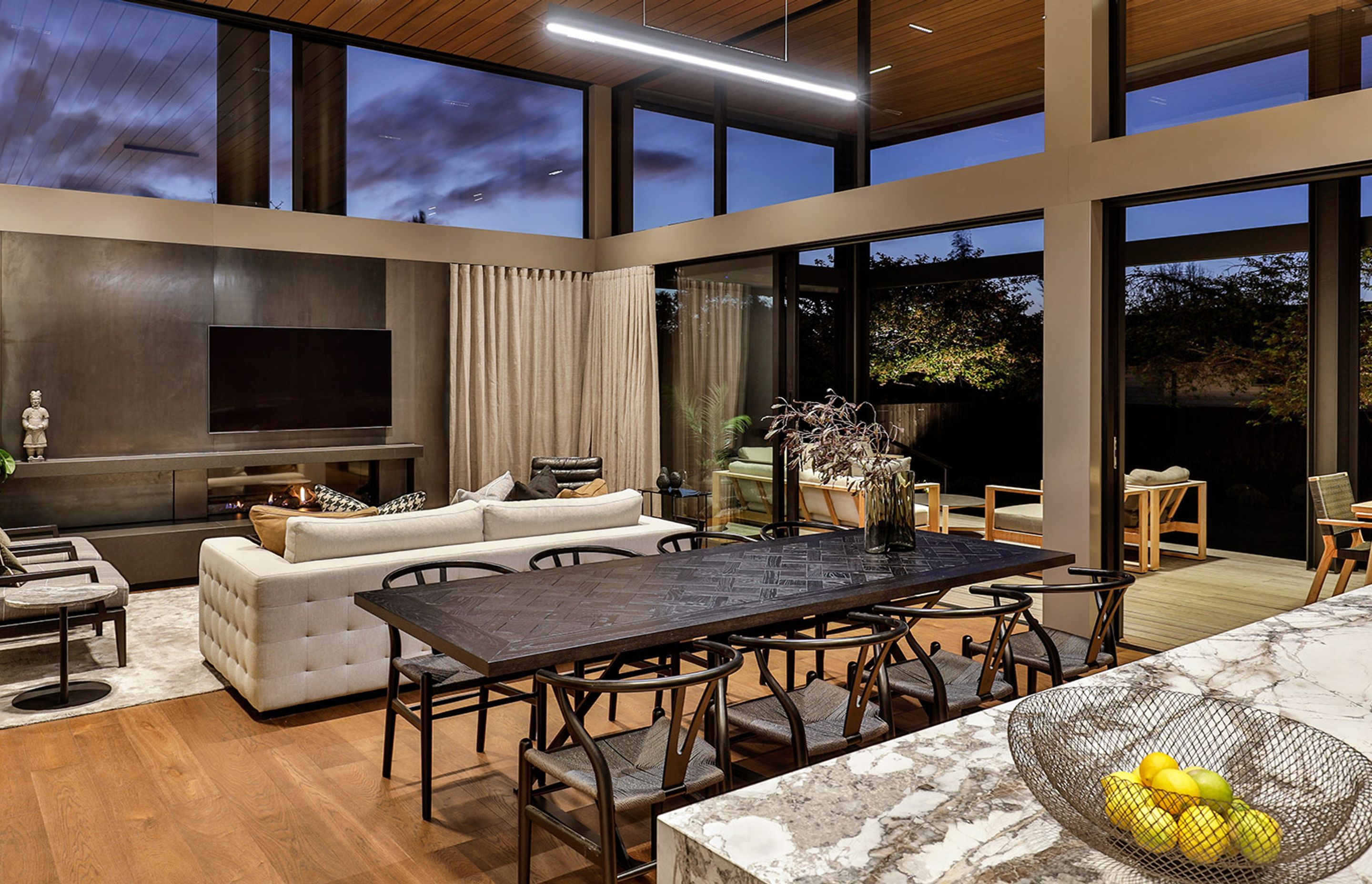 The main living area, designed with a striking feature wall and integrated fireplace made of blackened steel. | Photographer: Jamie Cobel