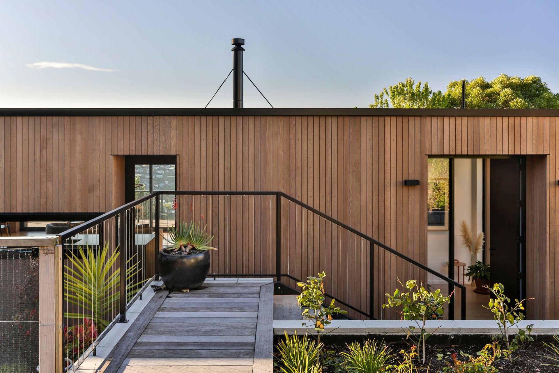 Pot plants grace the entryway of Jack House, a stunning timber clad home in Sumner in Canterbury - Photography: Jamie Cobel