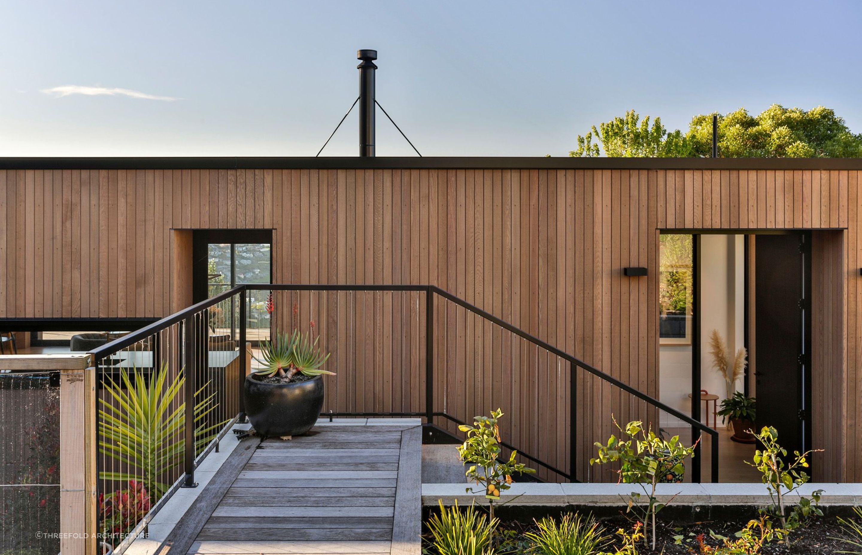 Pot plants grace the entryway of Jack House, a stunning timber clad home in Sumner in Canterbury - Photography: Jamie Cobel